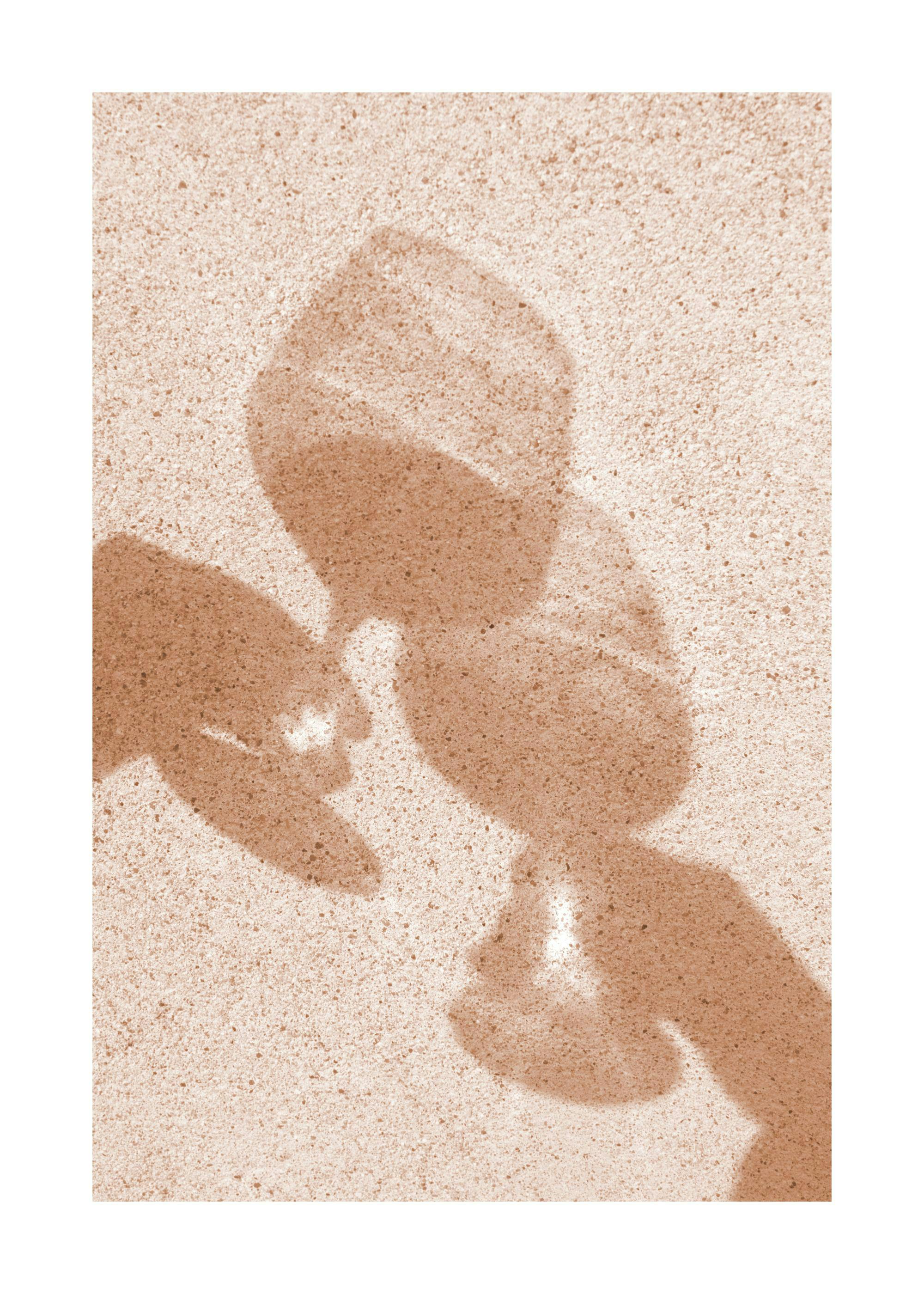 Plakat. Cień dwóch kieliszków na ziarnistym tle, letni nastrój.