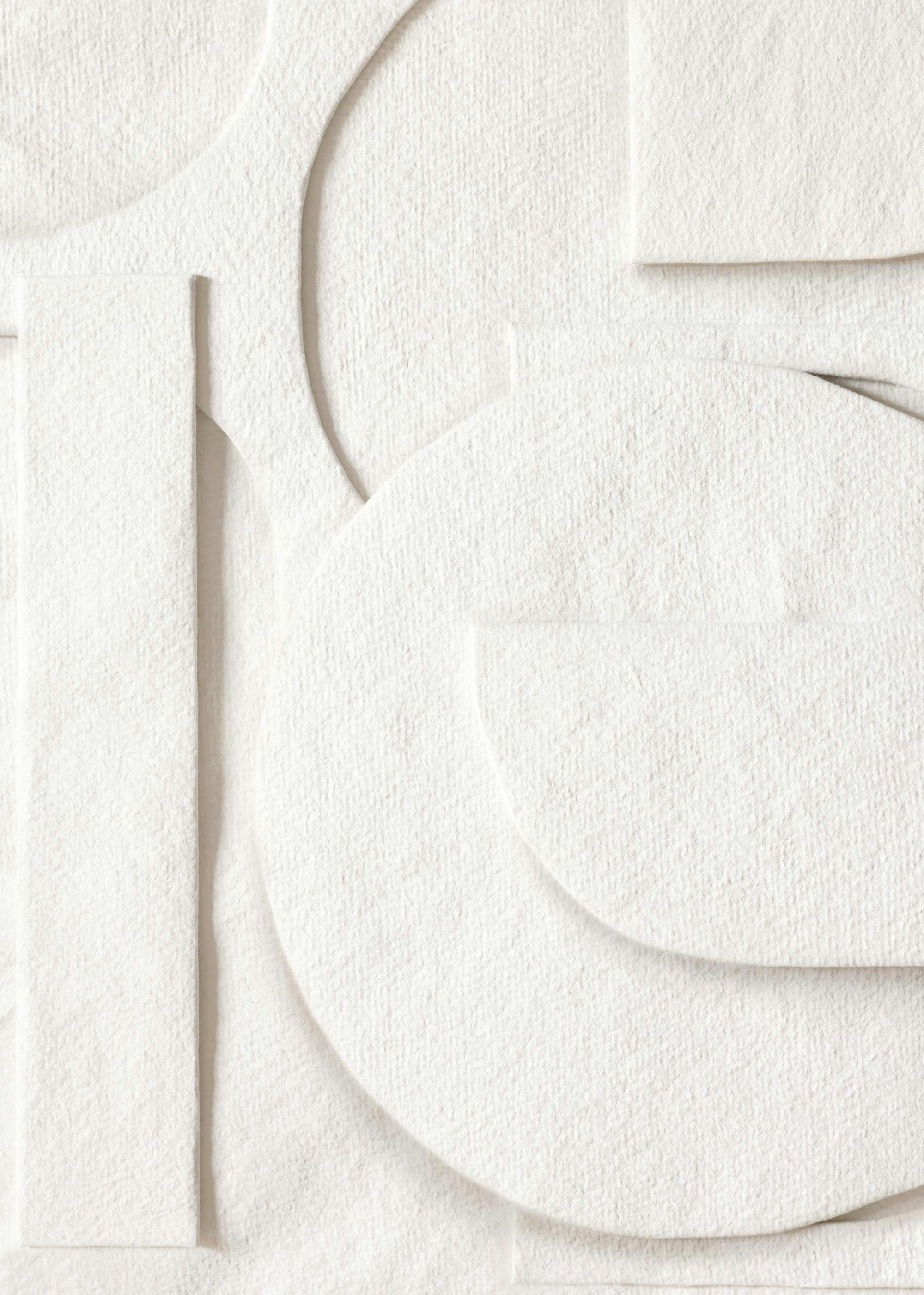Affiche de morceaux de papier découpés blancs, avec diverses formes circulaires et rectangulaires créant une illusion 3D.