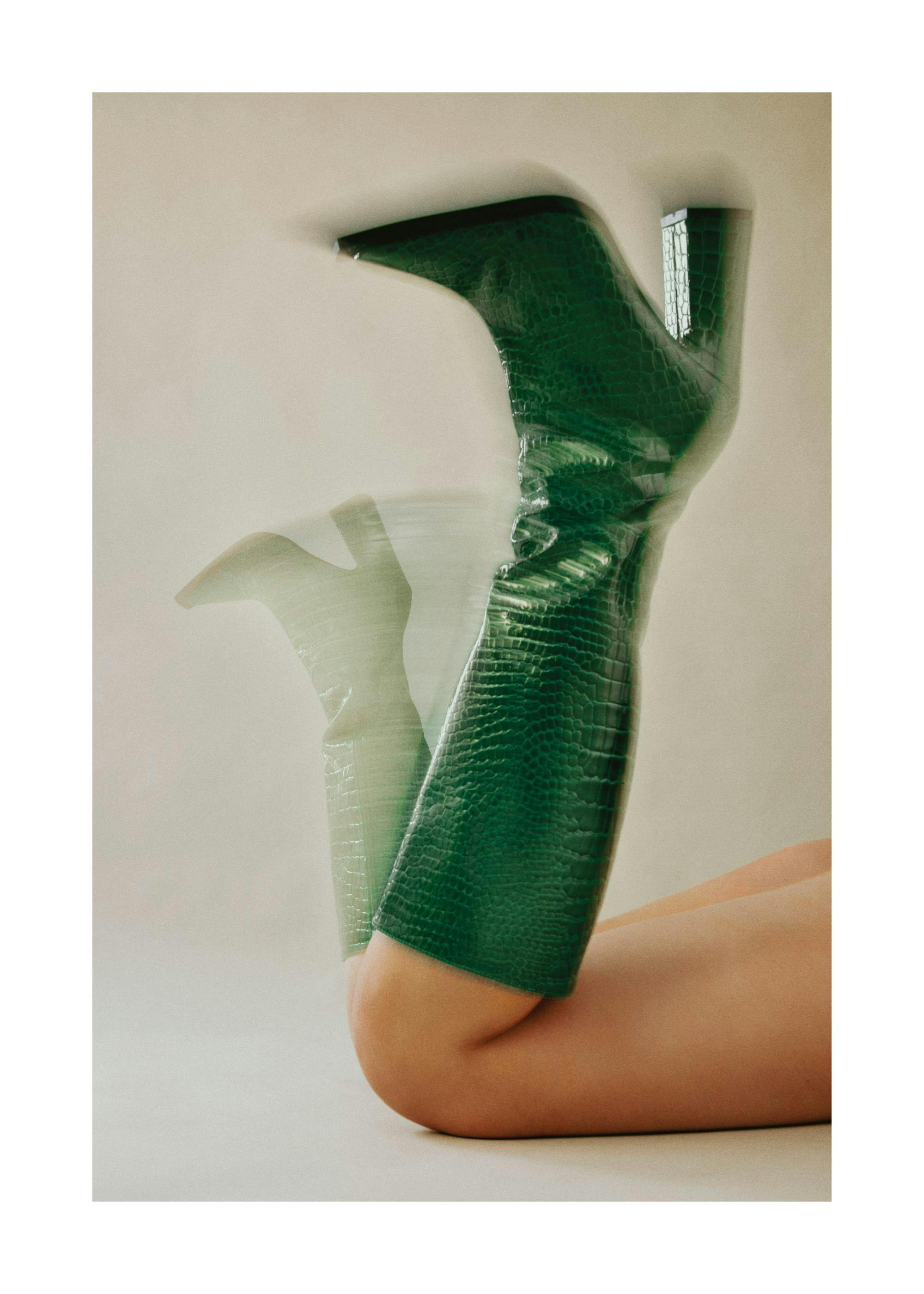 Vibrant green high-heeled boots with motion blur, creating a dynamic fashion photography poster.