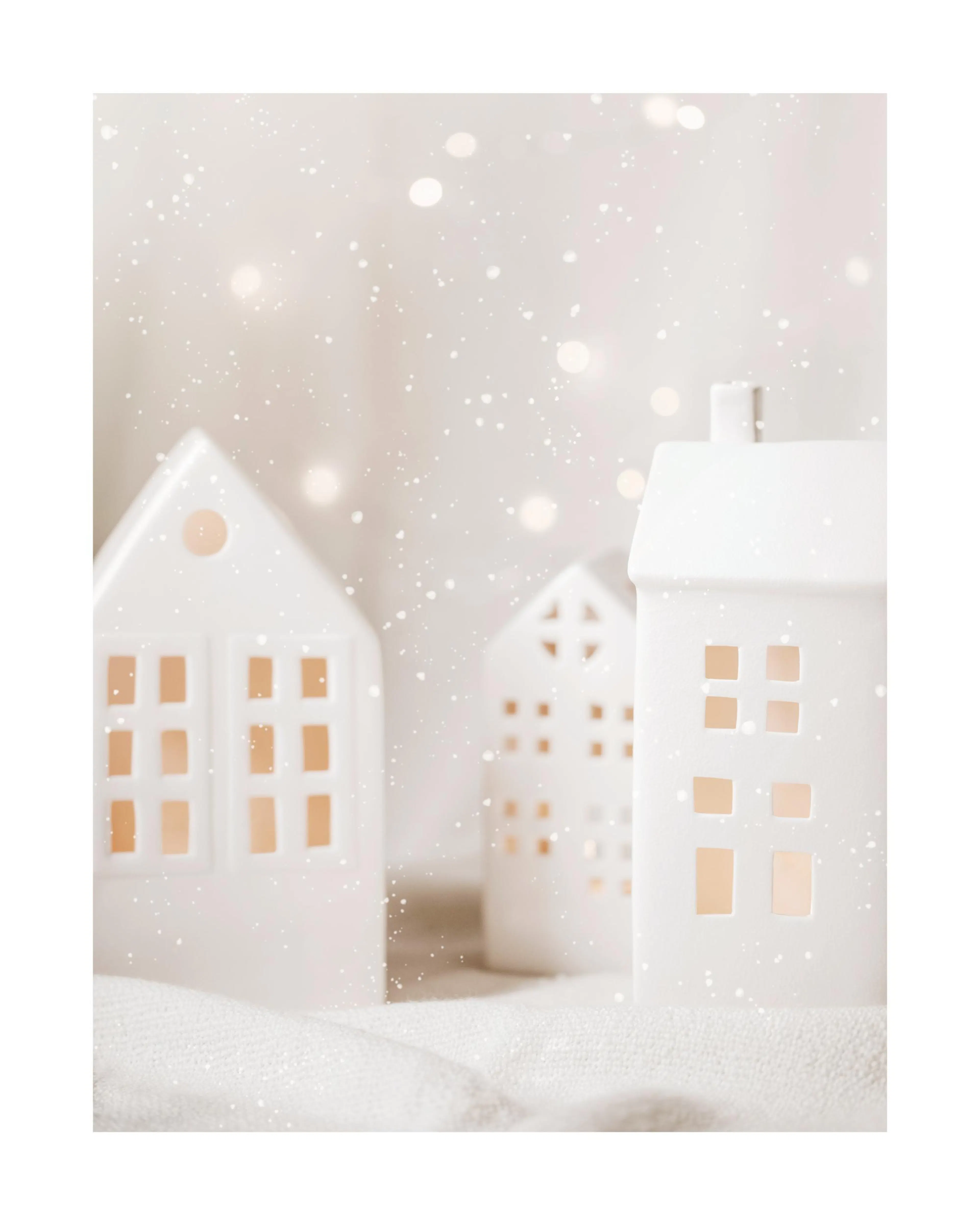 Póster de pueblo navideño con casas de porcelana blanca sobre textil, luces de invierno y nevada