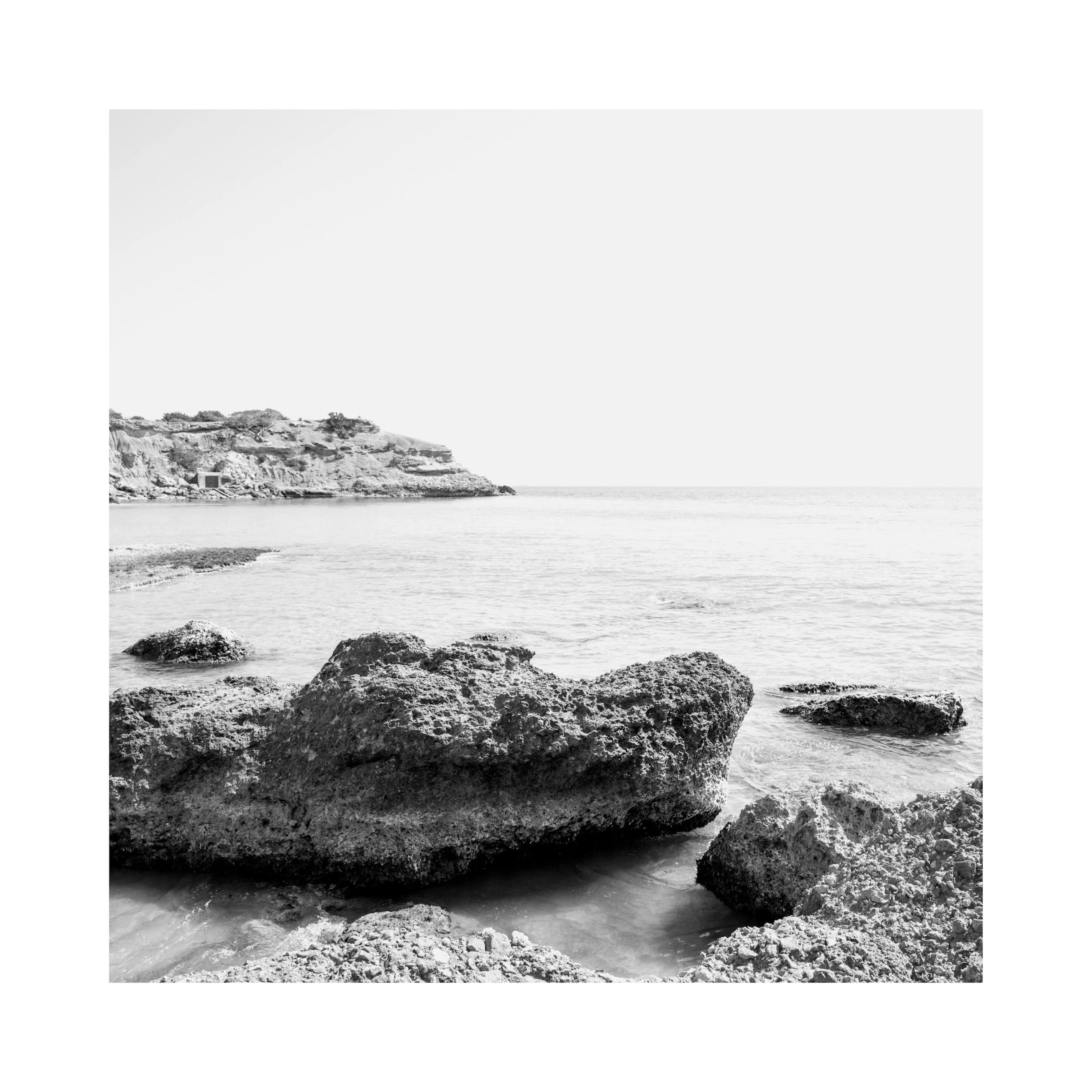 Poster fotografico monocromatico di costa rocciosa con mare e cielo. Arte murale natura.