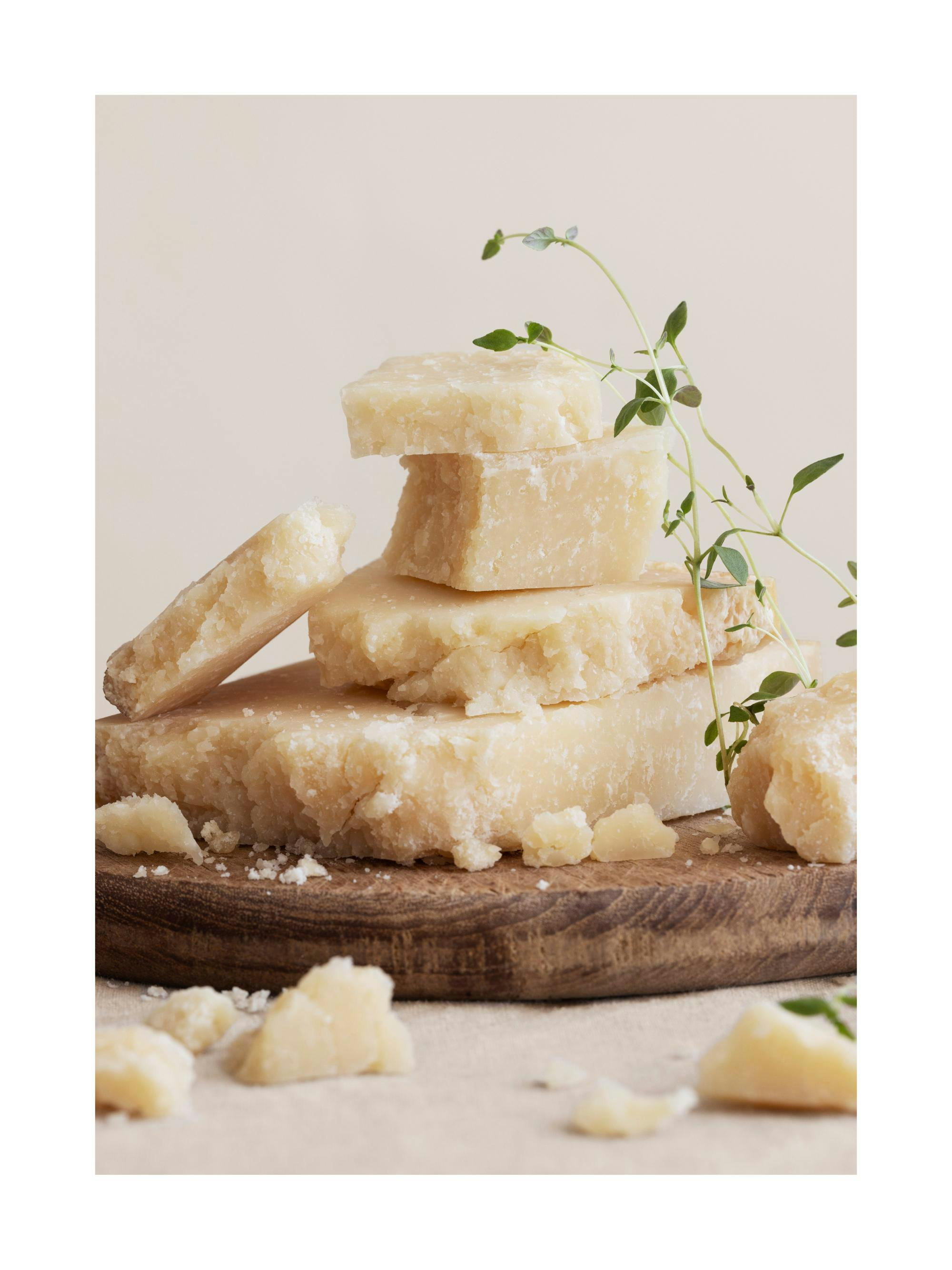 Φωτογραφικό πόστερ με παρμεζάνα σε ξύλο και κλαδιά θυμαριού, σε μπεζ φόντο