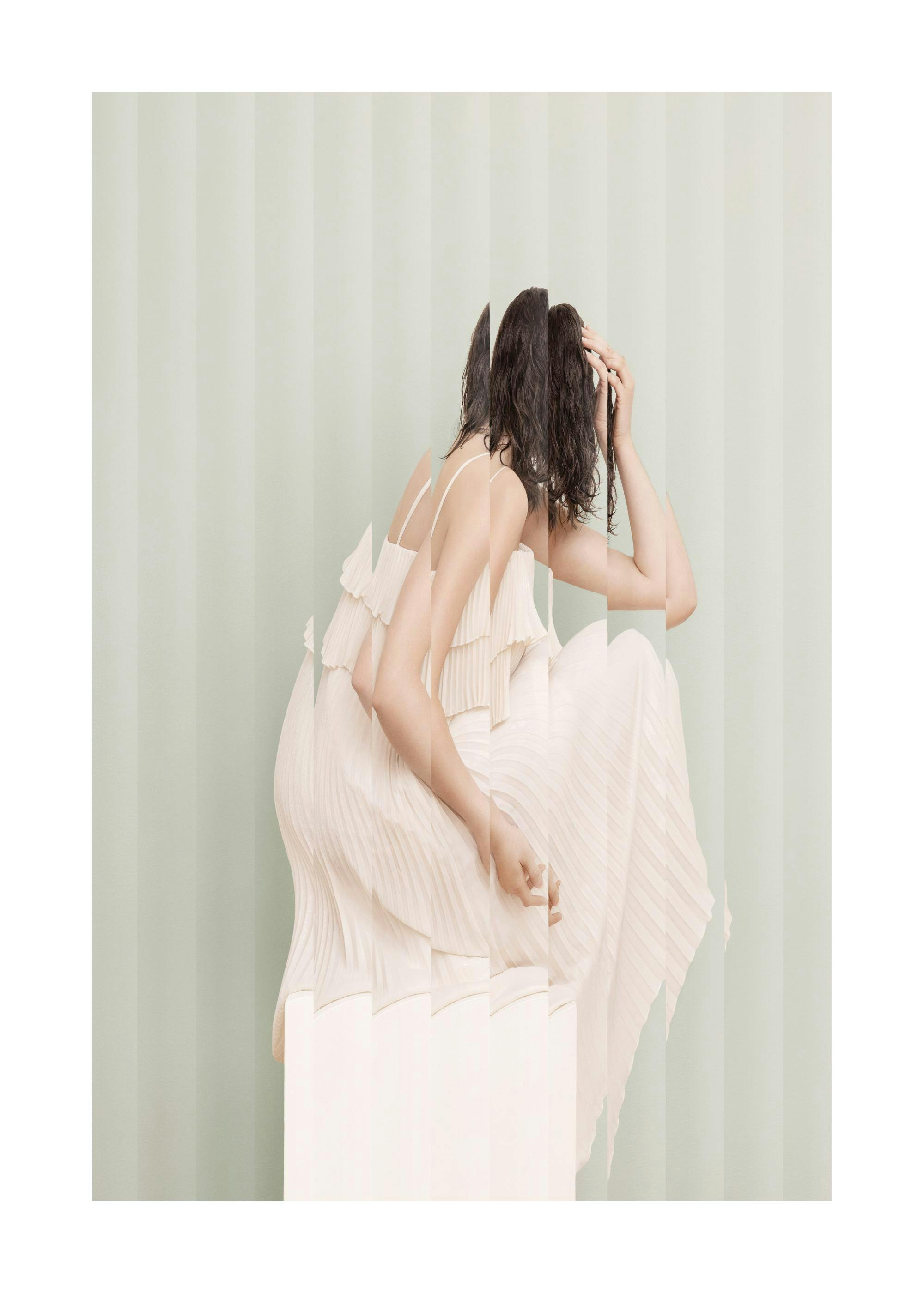 Portrait of woman in white dress with reeded glass effect, green striped background