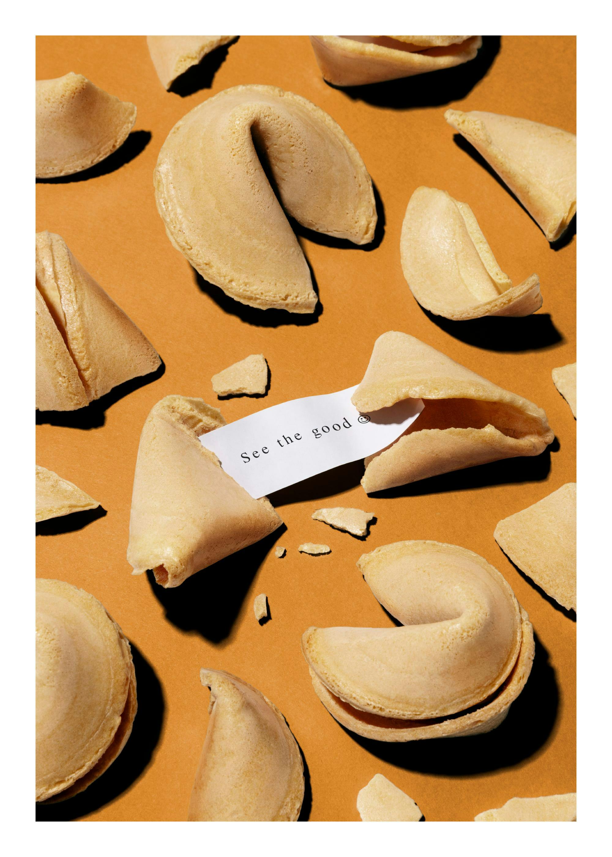 Affiche de biscuits de la fortune beiges sur fond orange, lun souvre pour révéler un message. Typographie visible.