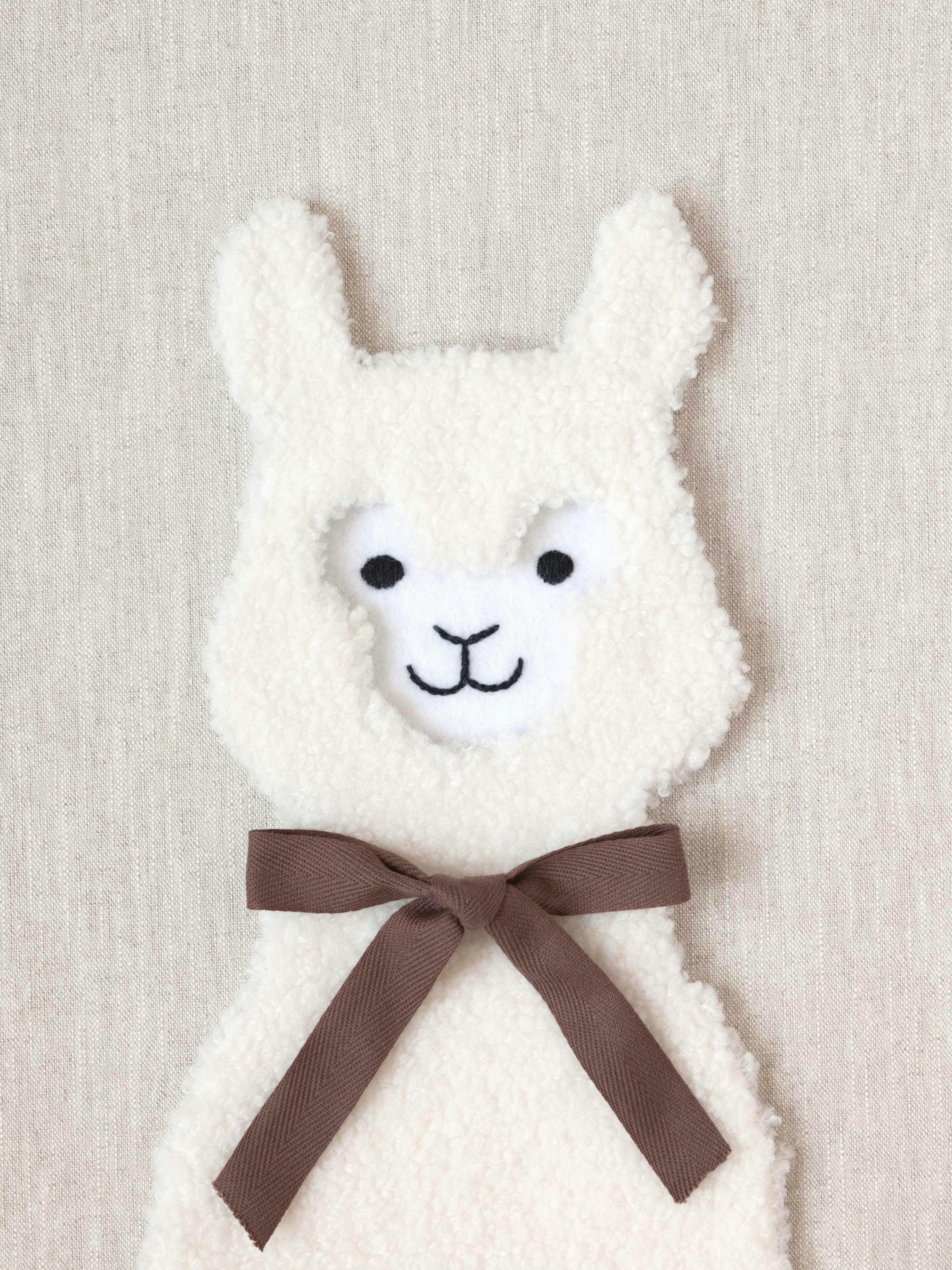 Pluizige witte lama met bruine strik op beige achtergrond, schattig kinderkamer poster design