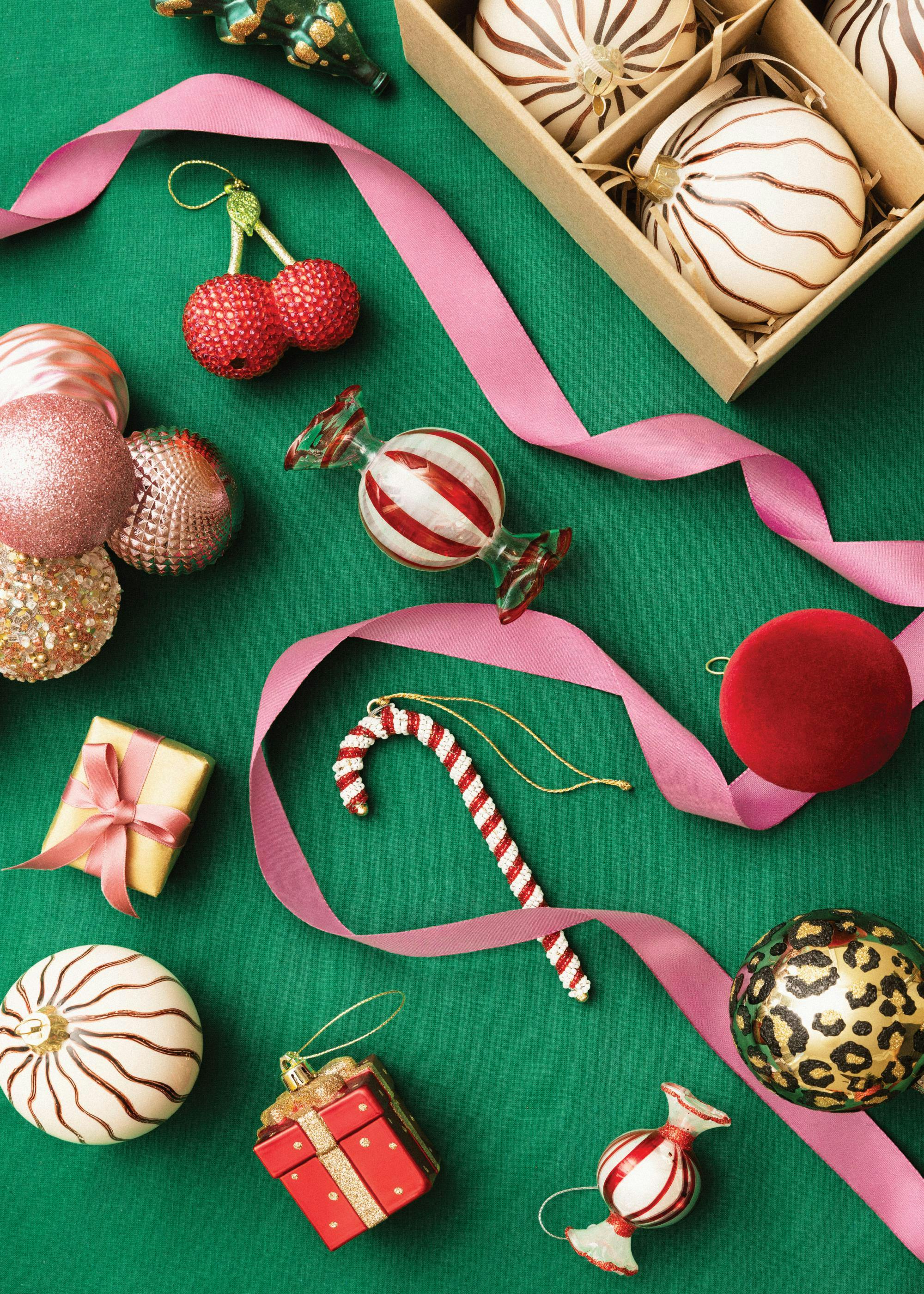 Festive Christmas decorations on green, featuring baubles, candy cane, and gifts with pink ribbon.