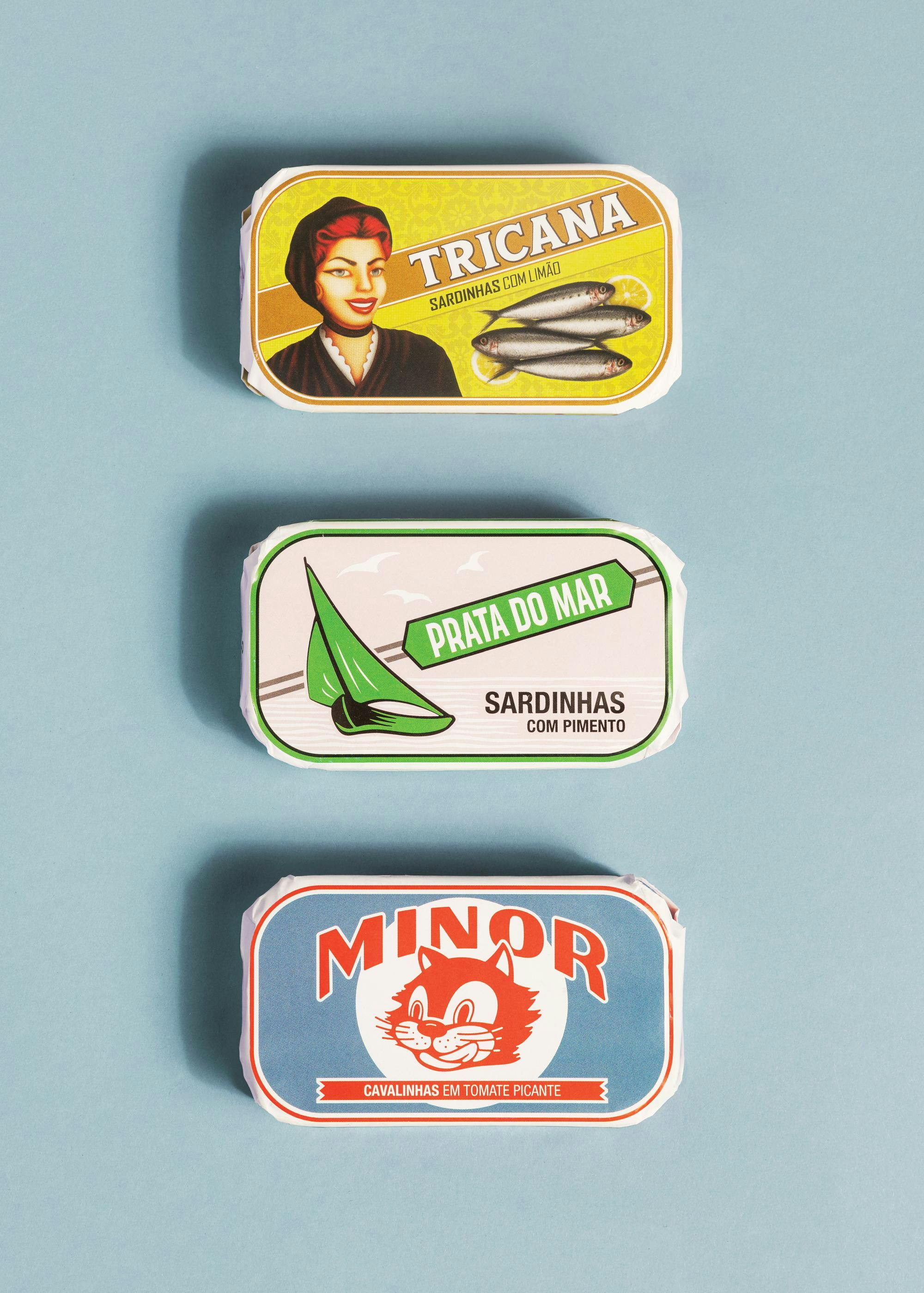 Poster com três latas de conservas portuguesas coloridas, incluindo sardinhas e cavalinhas, sobre fundo azul.