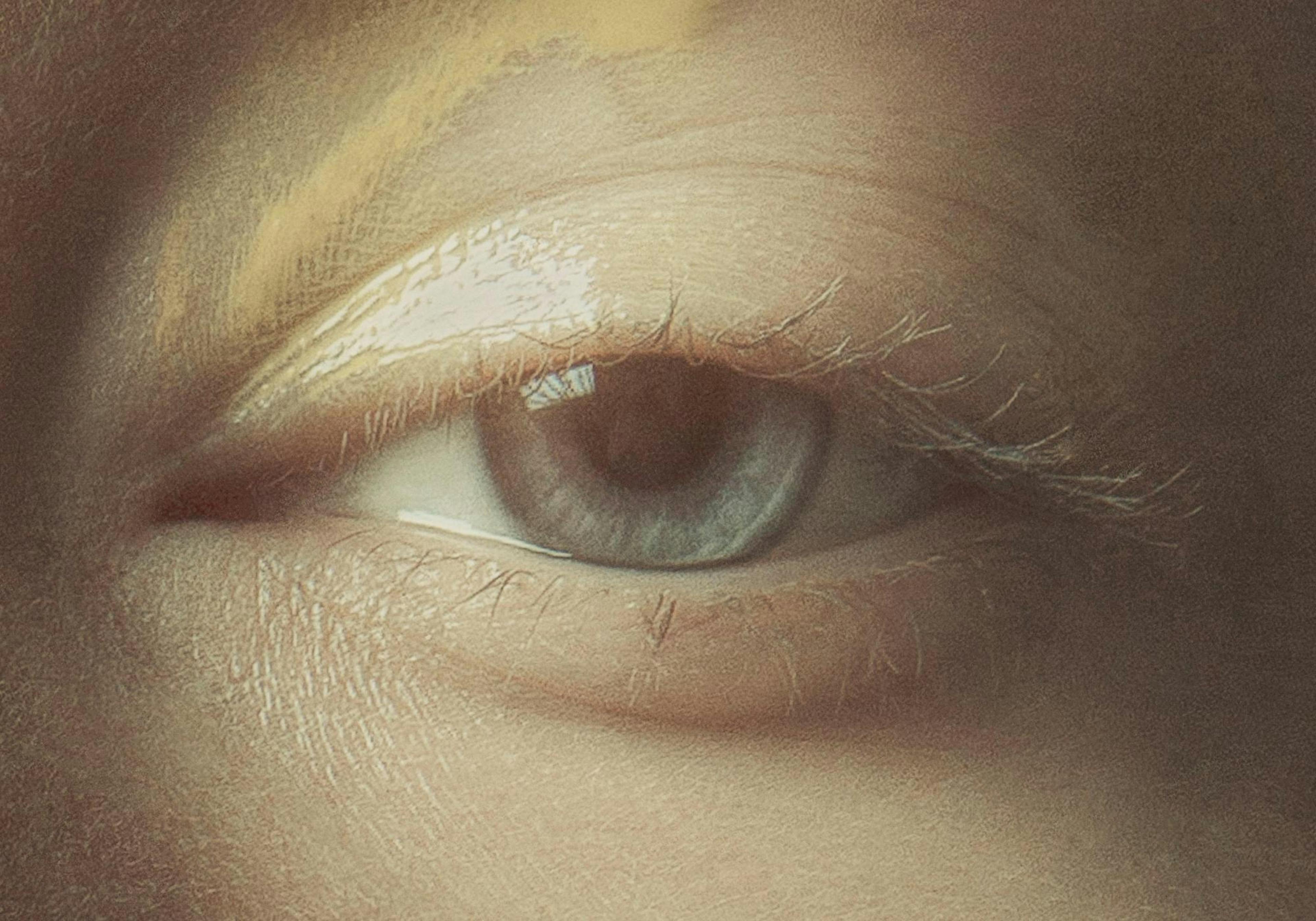 Detailed close-up print of a light blue eye with visible skin texture and faint eyelashes.