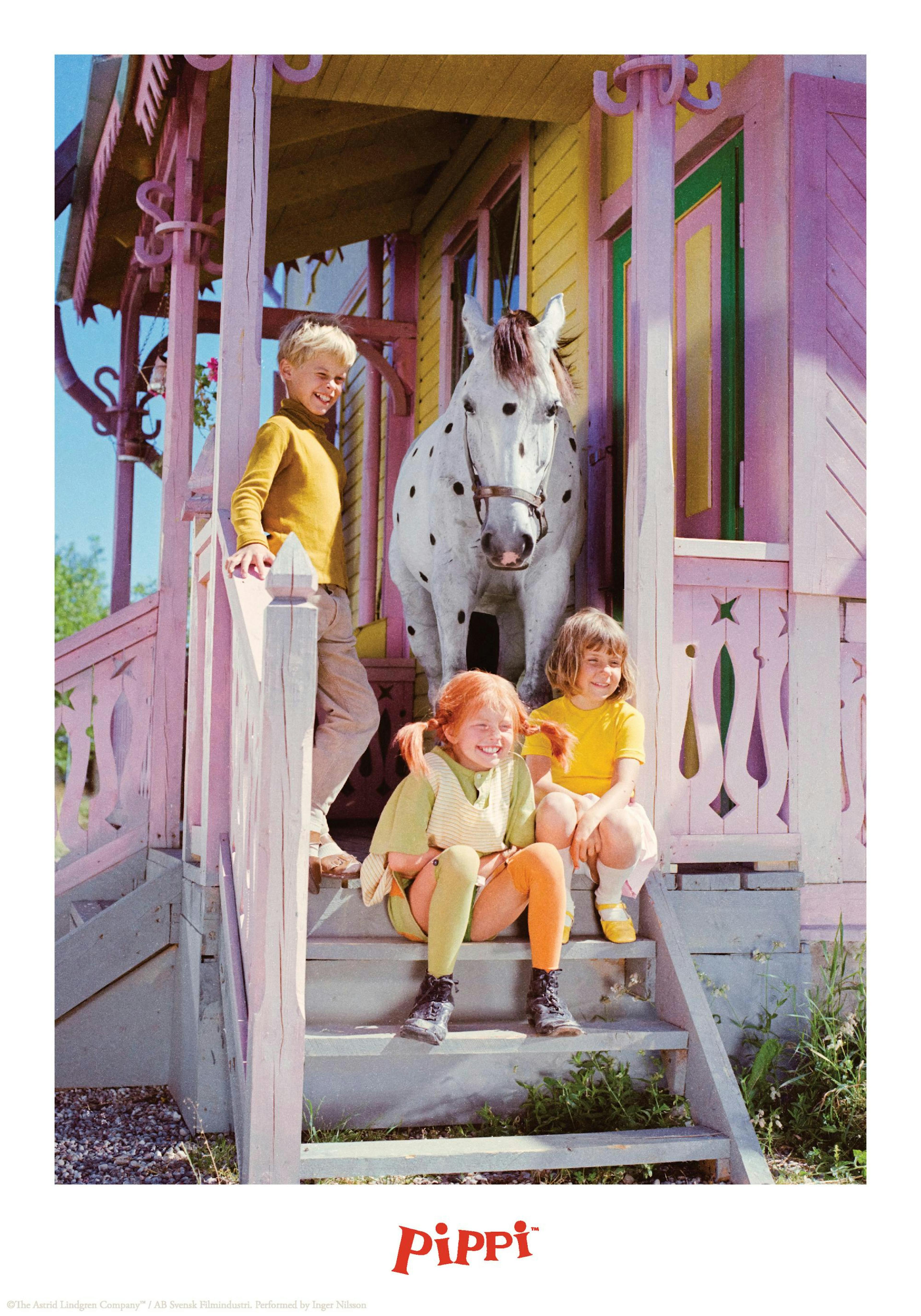 カラフルな家と階段に立つ子供たち、そして馬が描かれた愉快なポスター。 ポスター下部には「Pippi」のロゴ。
