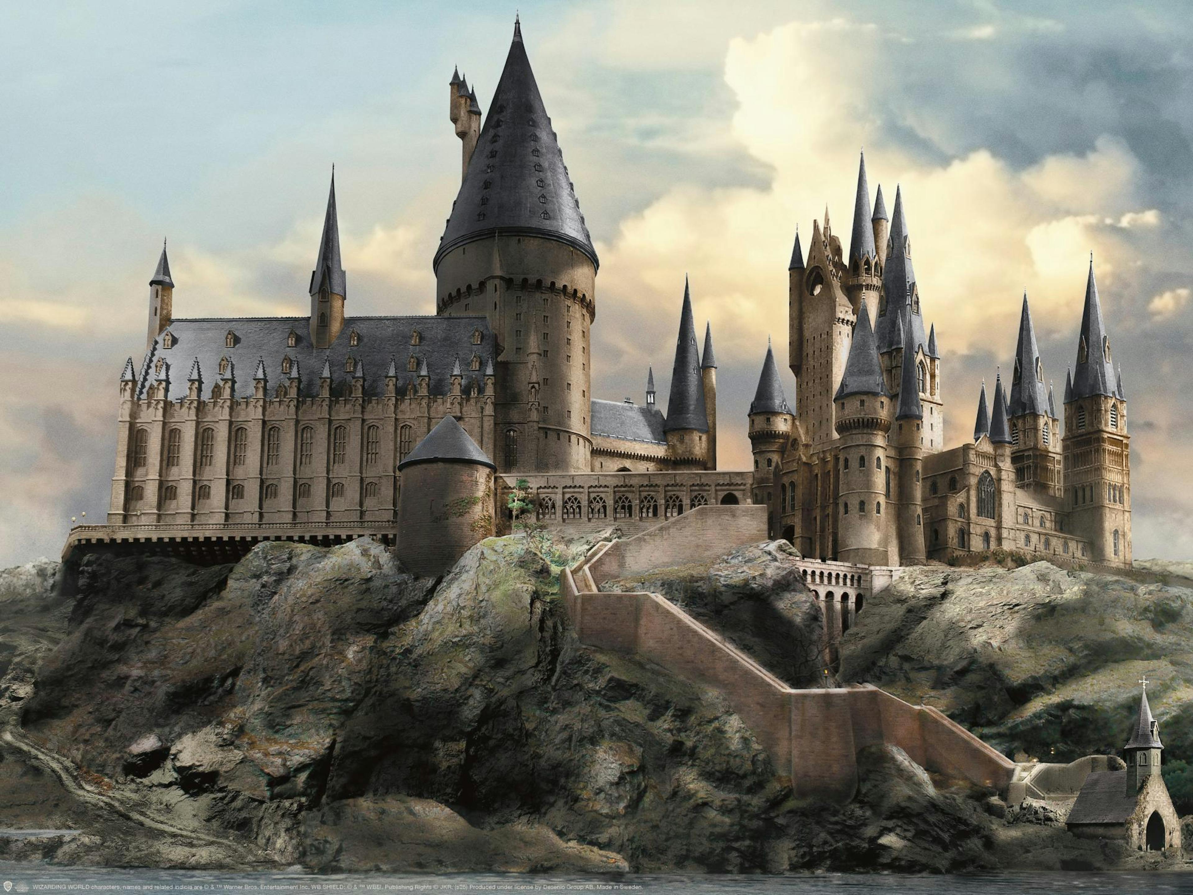 Harry Potter Hogwarts-plakat med det majestætiske slot på en klippeø under en overskyet himmel.