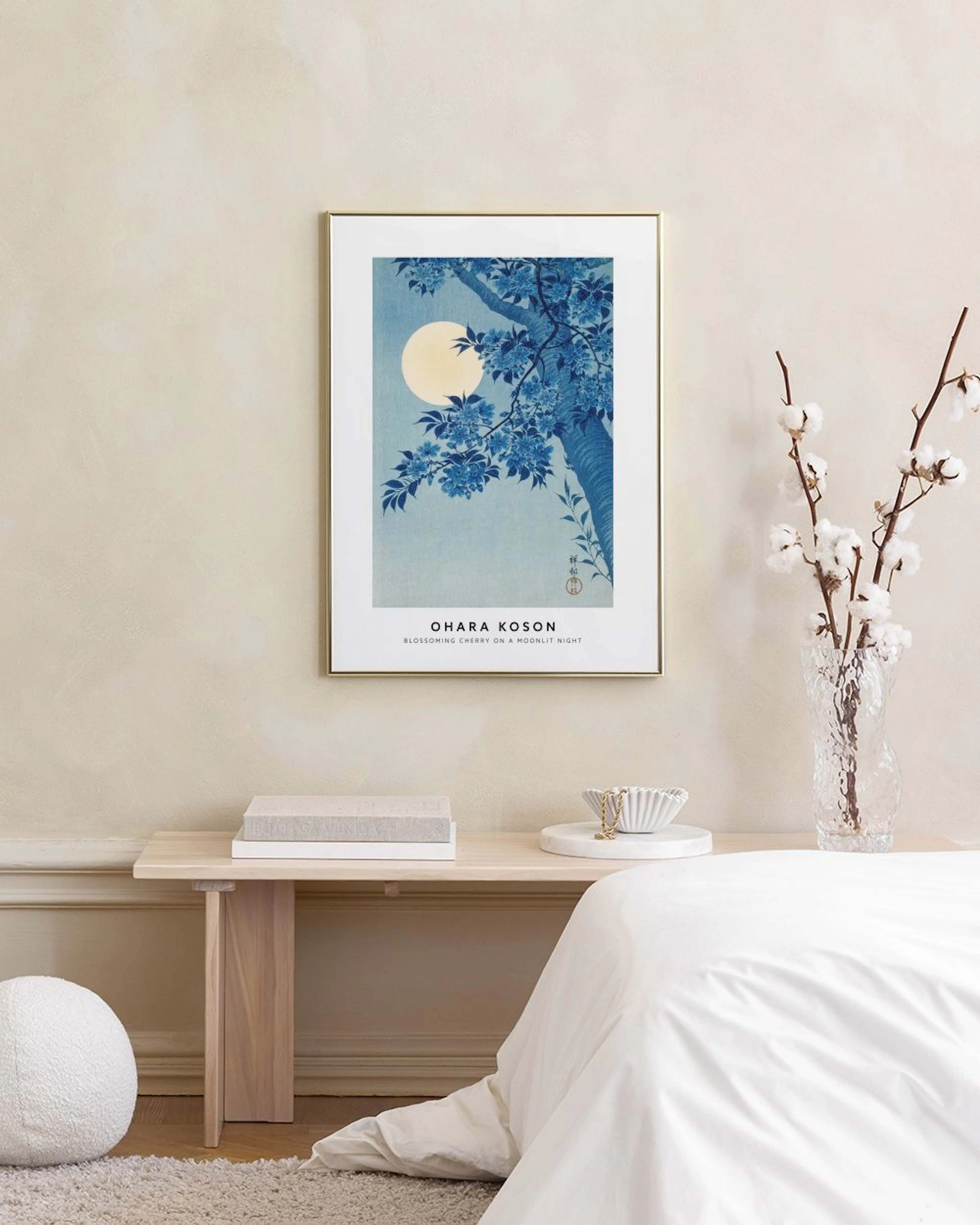 Affiche japonaise dun cerisier en fleurs sous la pleine lune, aux teintes de bleu et jaune, affichée au-dessus dun meuble bleu.