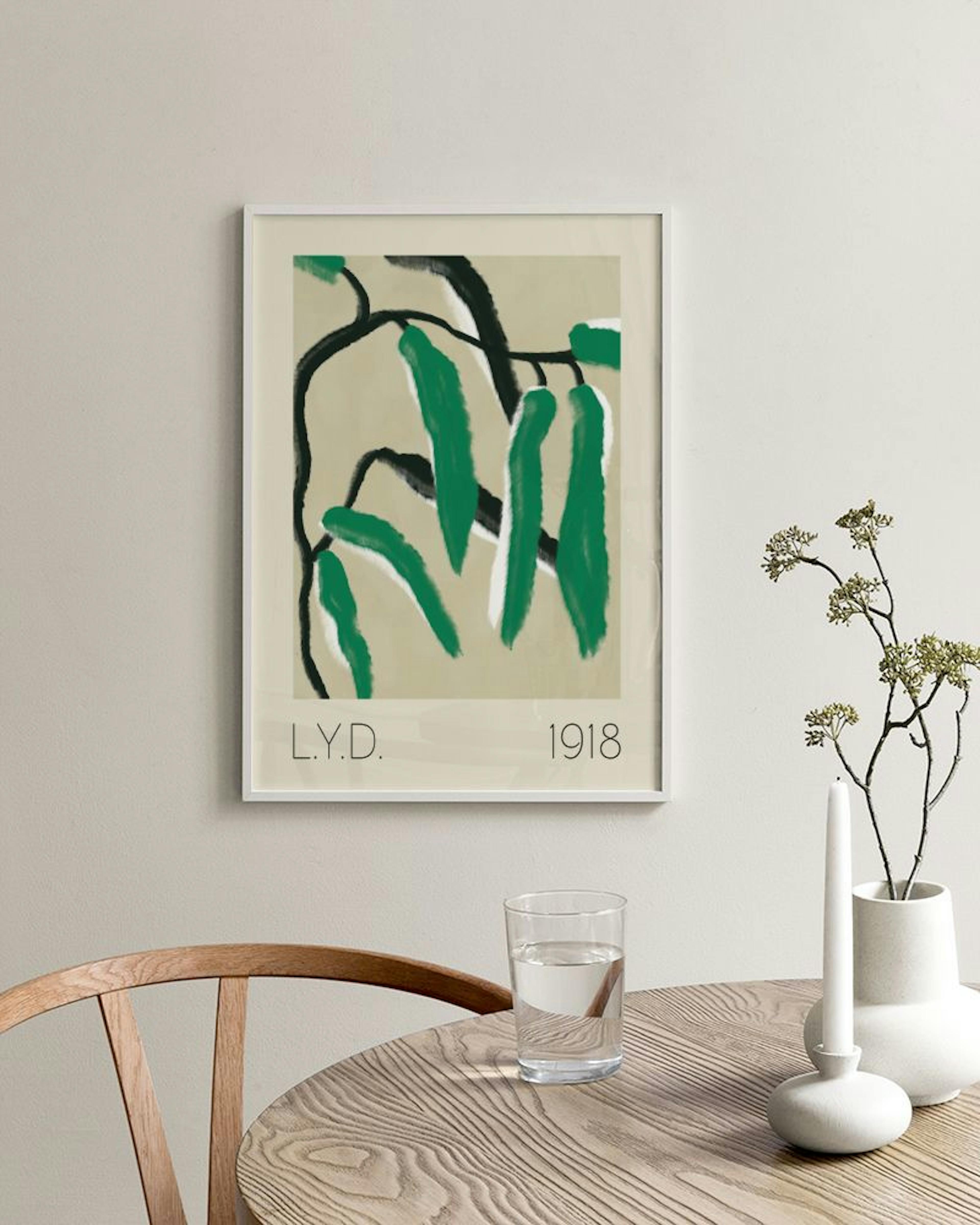 A print of abstract green leaves and black branches on a beige background, hanging on a cream wall above a green ottoman.