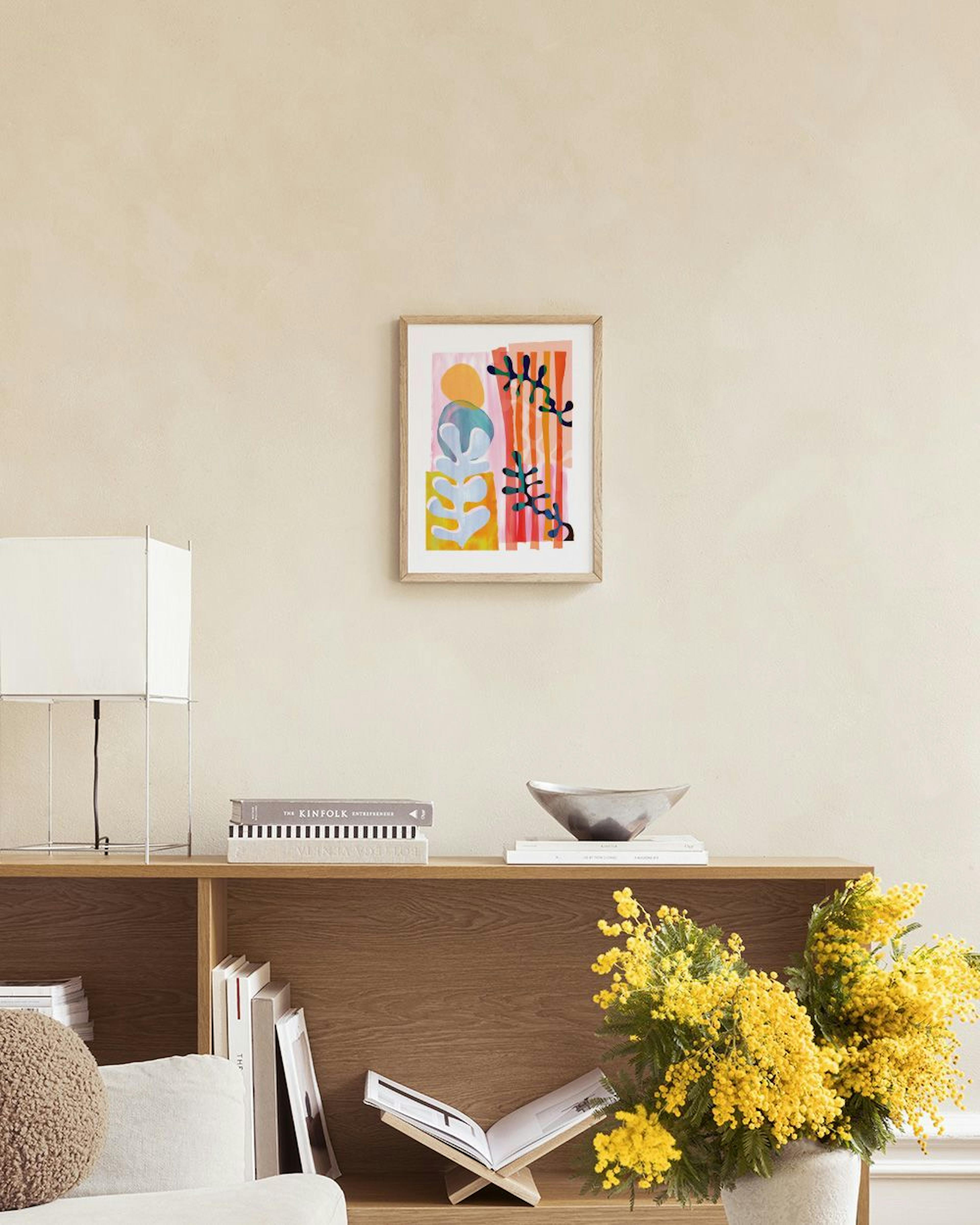 Poster astratto con forme organiche rosa, arancioni e azzurre, e rami scuri su sfondo chiaro, appeso sopra un mobile bianco con 