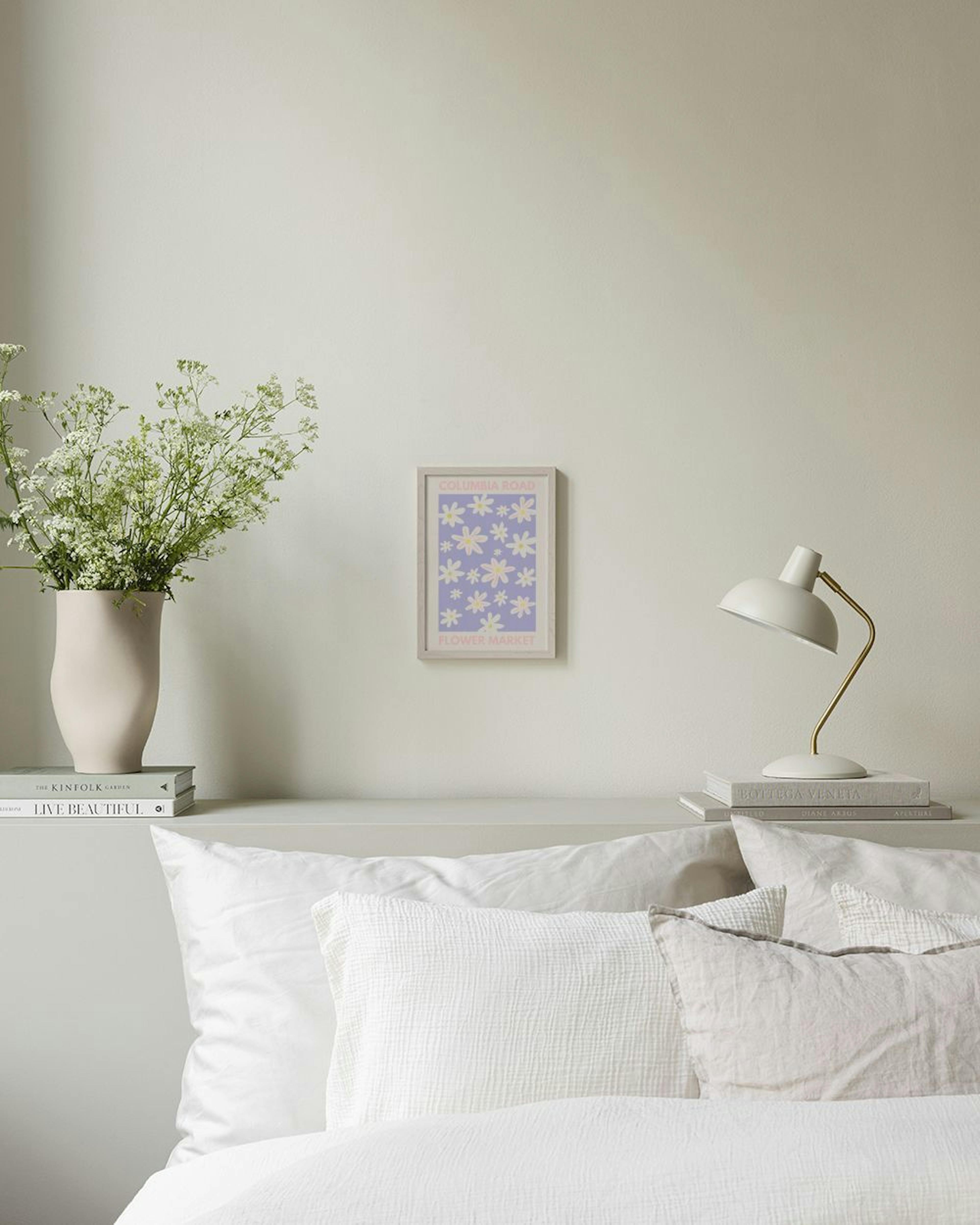 A print with COLUMBIA ROAD FLOWER MARKET text and white daisies on a lavender background, hanging above a white textured bowl on
