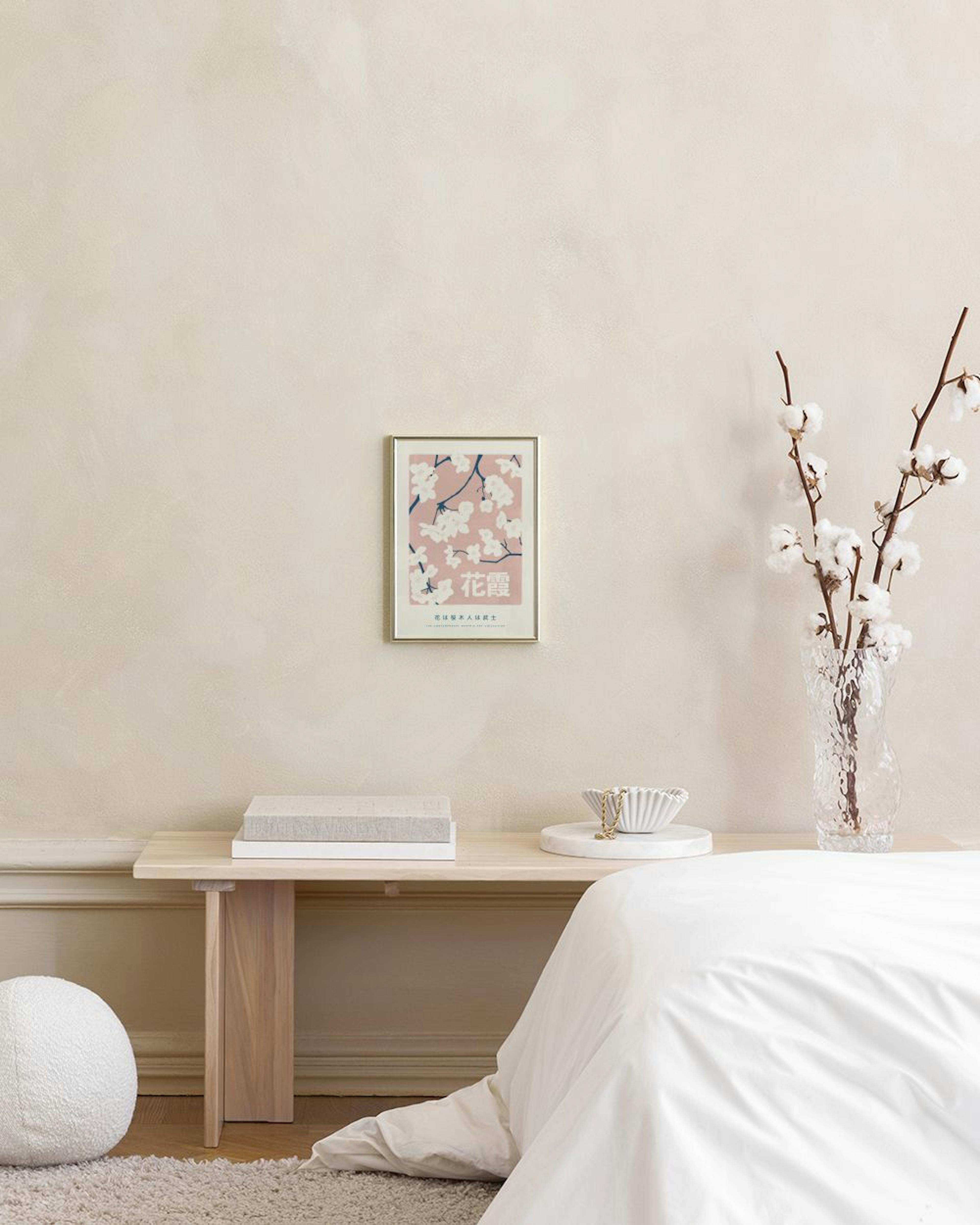 Poster mit weißer Kirschblüte und japanischen Schriftzeichen auf rosa Hintergrund, über einem Beistelltisch mit Vasen.