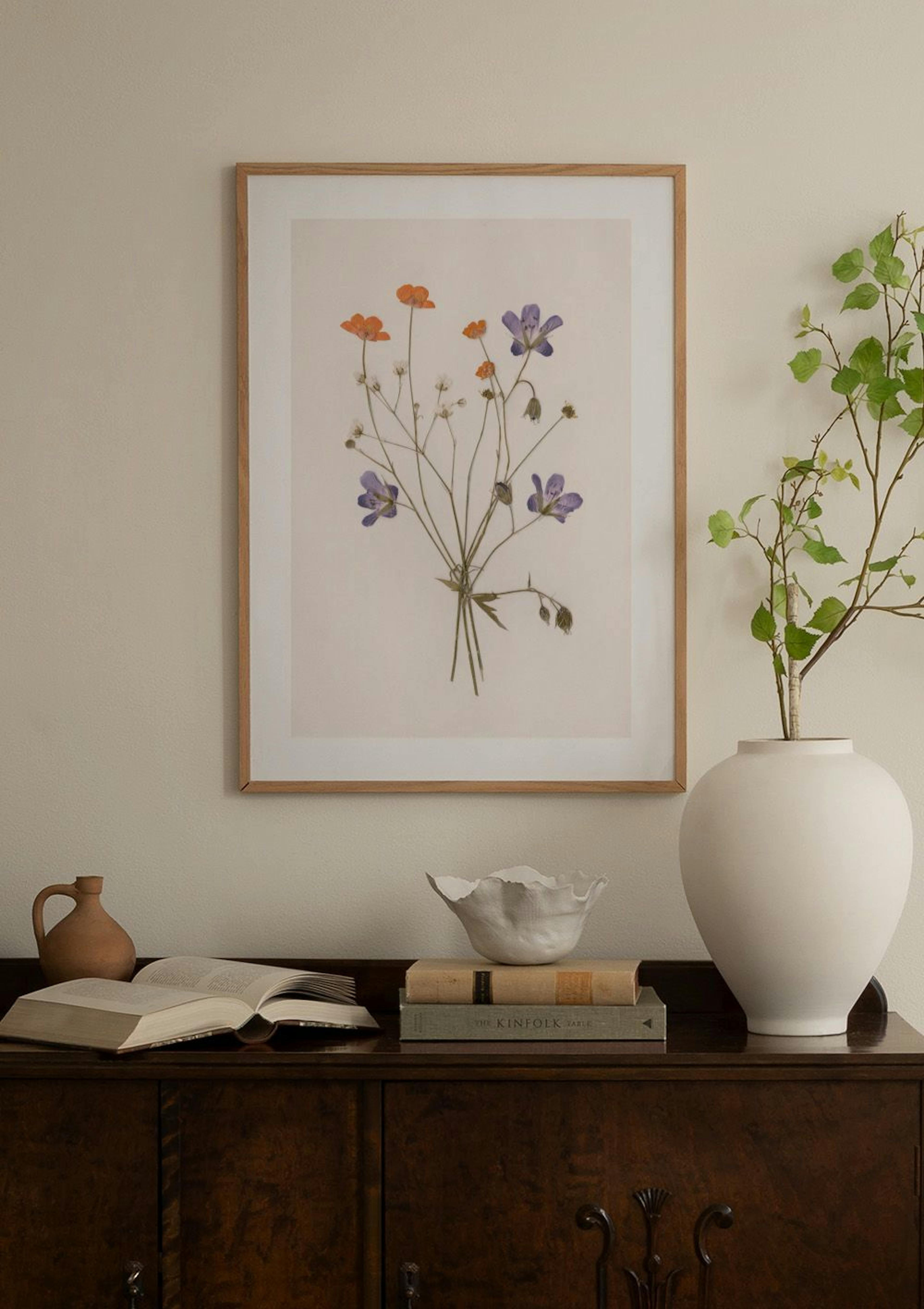 Poster eines Blumenstraußes mit orangefarbenen und violetten Blüten, der in einem modernen Raum über einem Beistelltisch hängt.