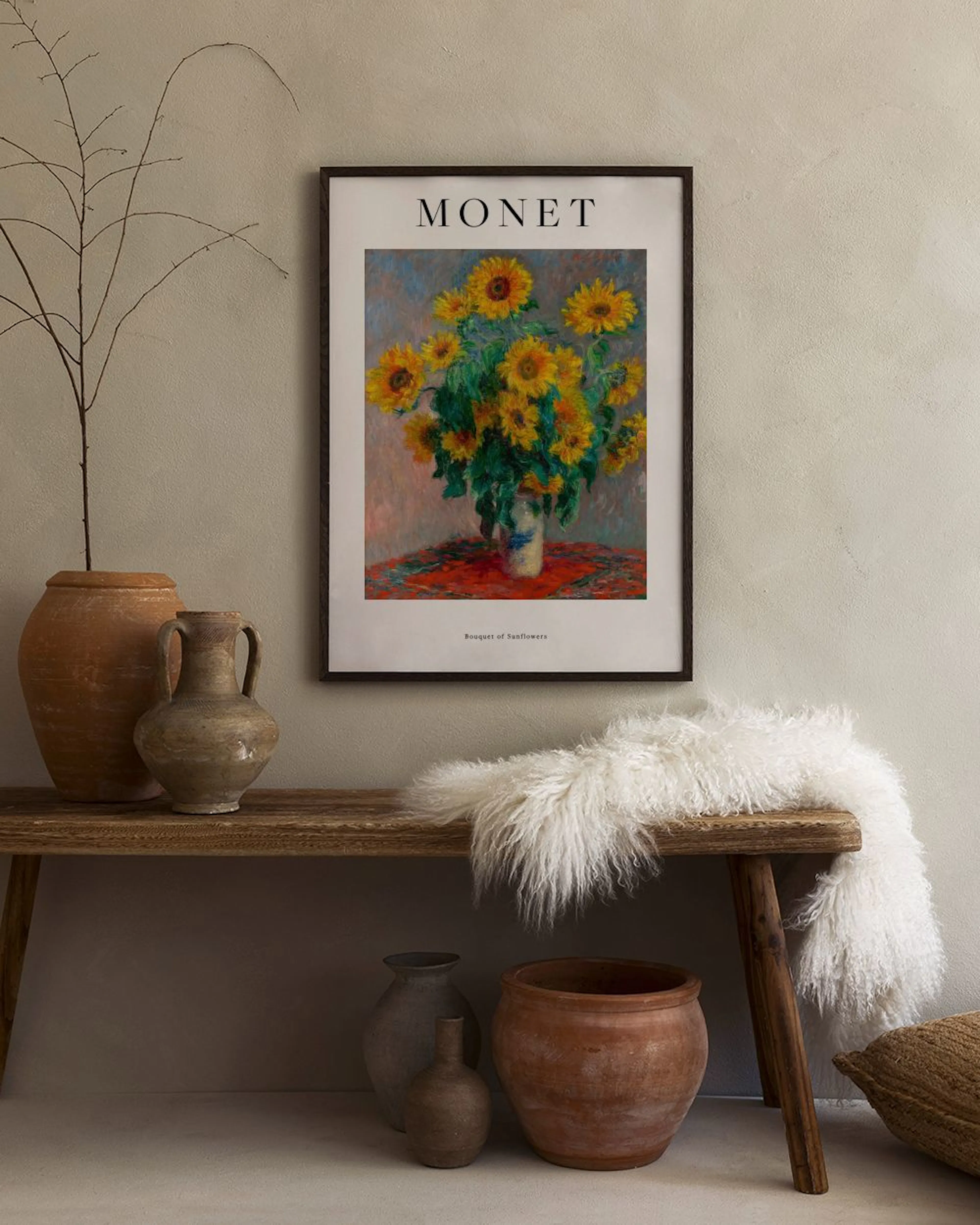 Poster de Monet com girassóis num jarro, pendurado numa parede clara acima de uma poltrona cinzenta, com um pedestal branco e va