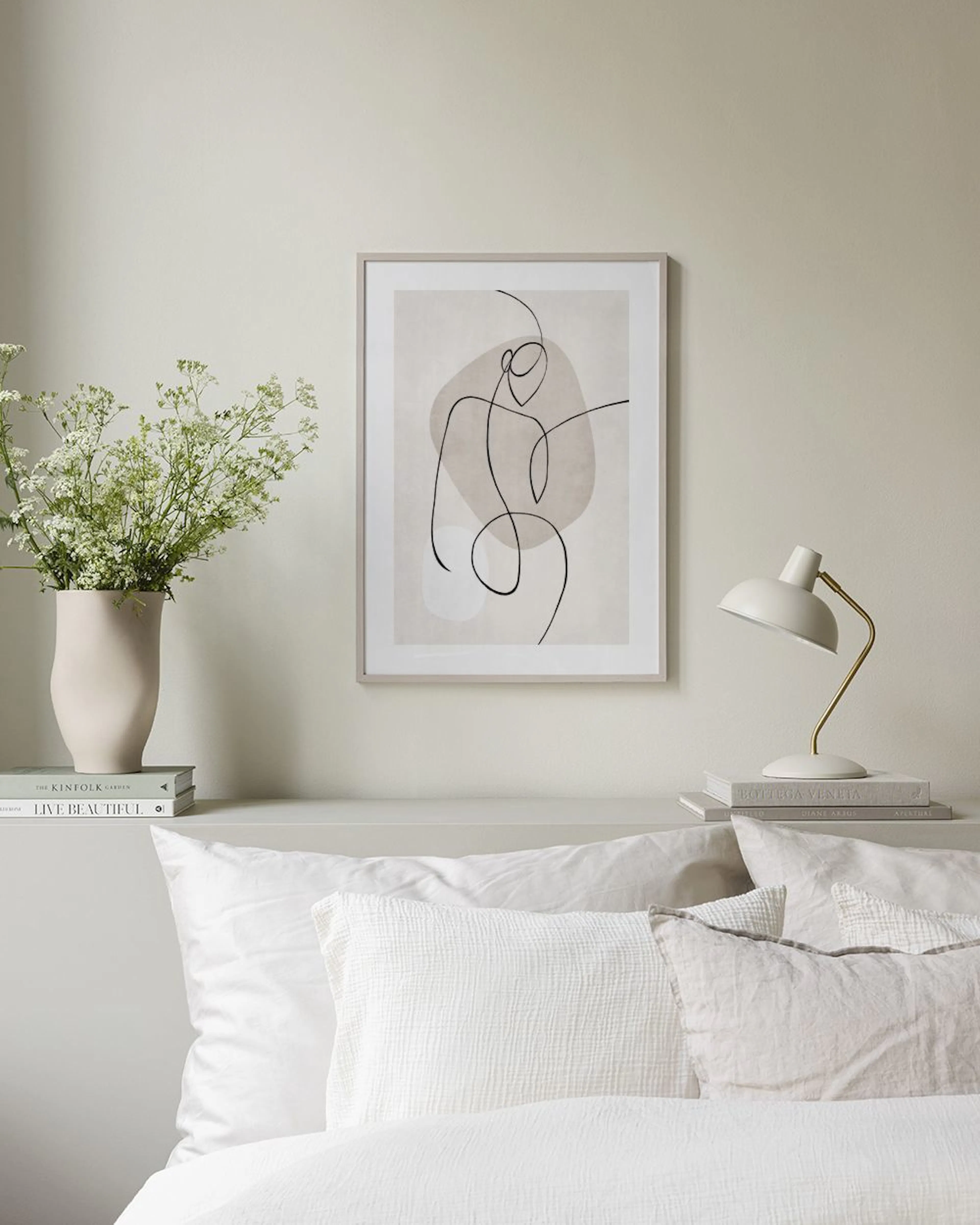 Abstracte poster met een zwarte lijntekening van een lichaam en organische vormen in grijs en beige, hangend boven een marmeren 
