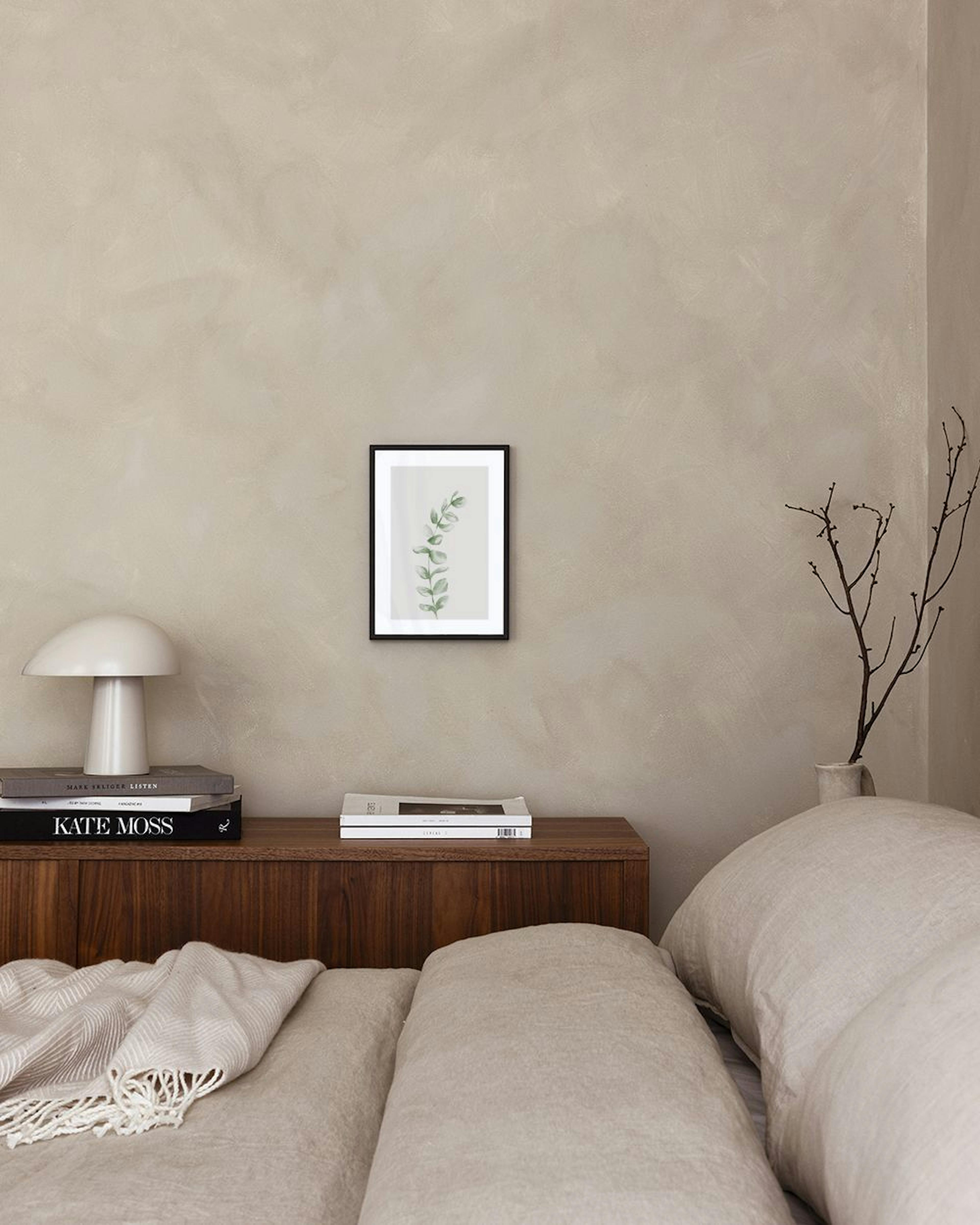 A print of a delicate green eucalyptus branch with individual leaves, displayed above a grey concrete shelf with a white vase an