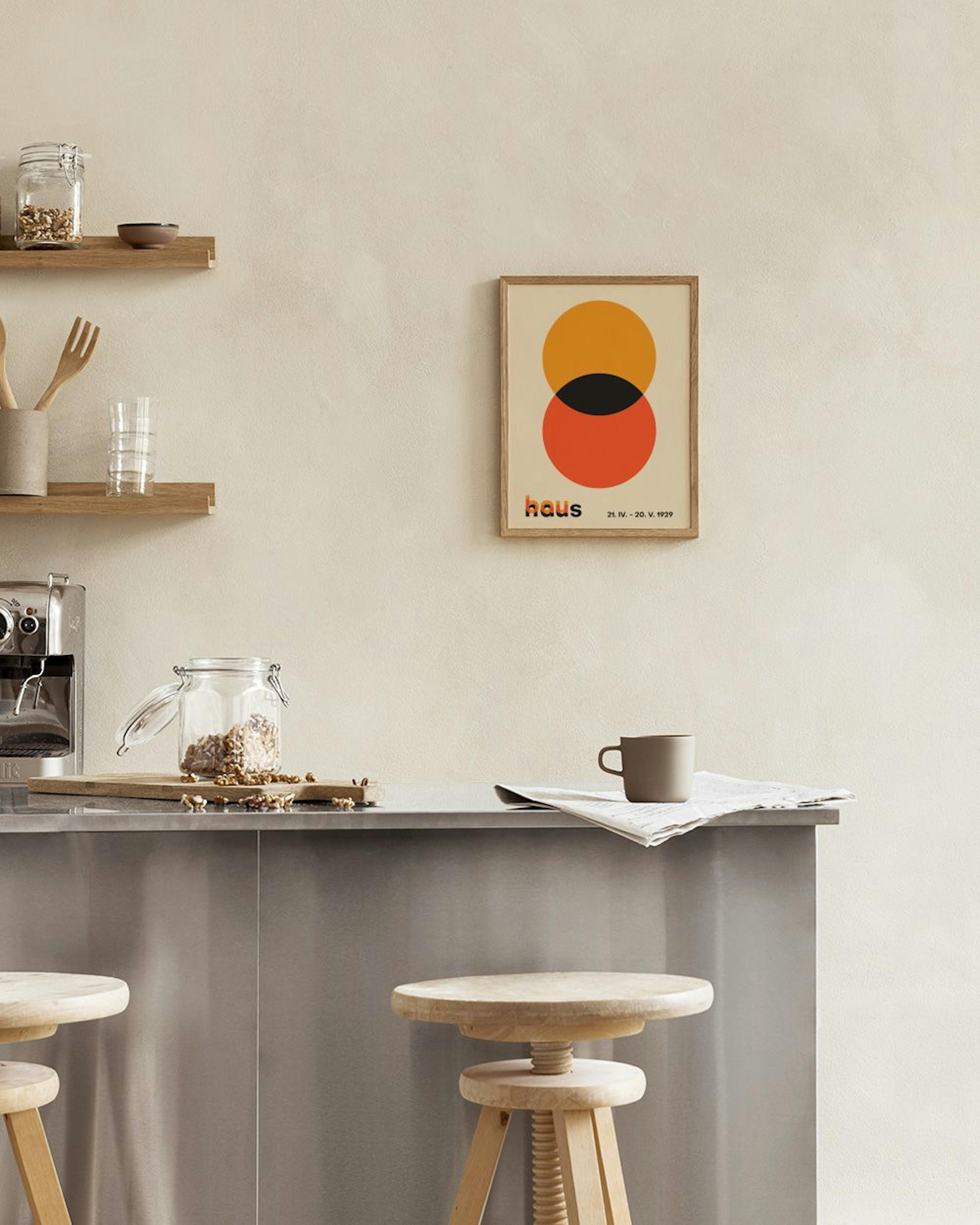 Plakat med to overlappende cirkler i orange og rød, med sort overlap, ophængt over en sort metalkonsol med vaser og bøger.