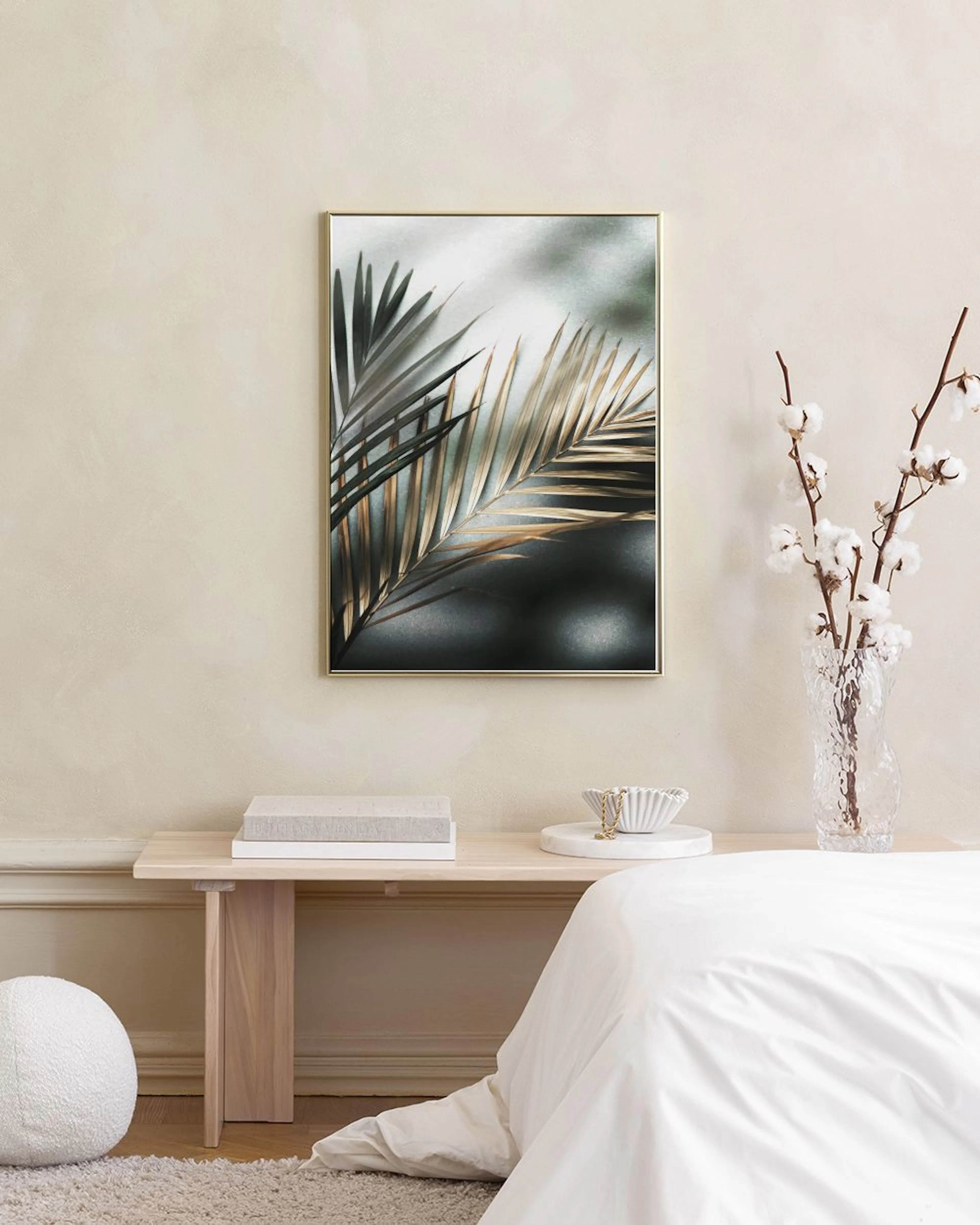 Poster med palmblad i gröna och bruna nyanser, hängande på en mörkgrön vägg i ett rum med sammetsgardiner och mjuk matta.