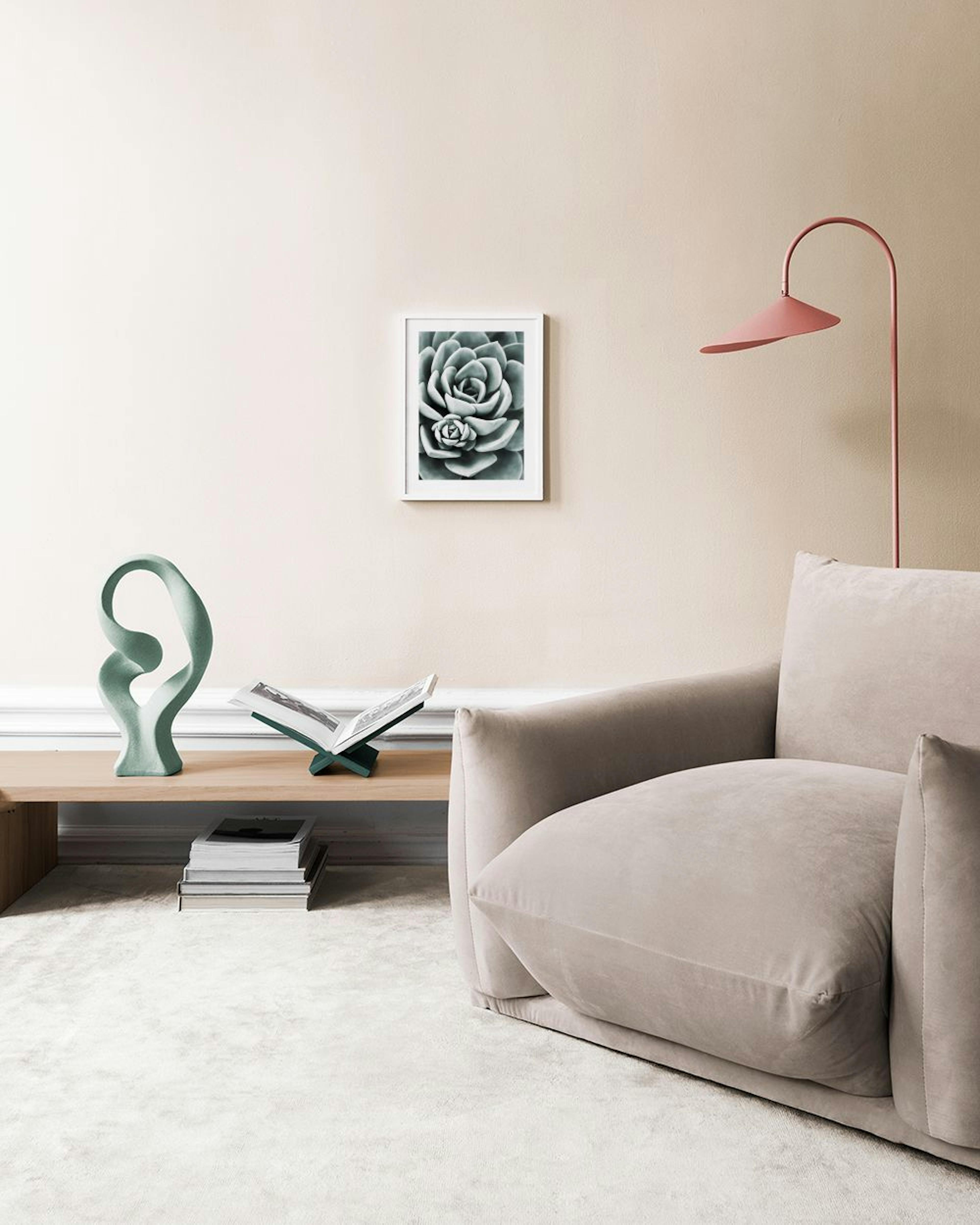Póster de una suculenta en blanco y negro colgando sobre un banco de madera con jarrones decorativos y una maceta.