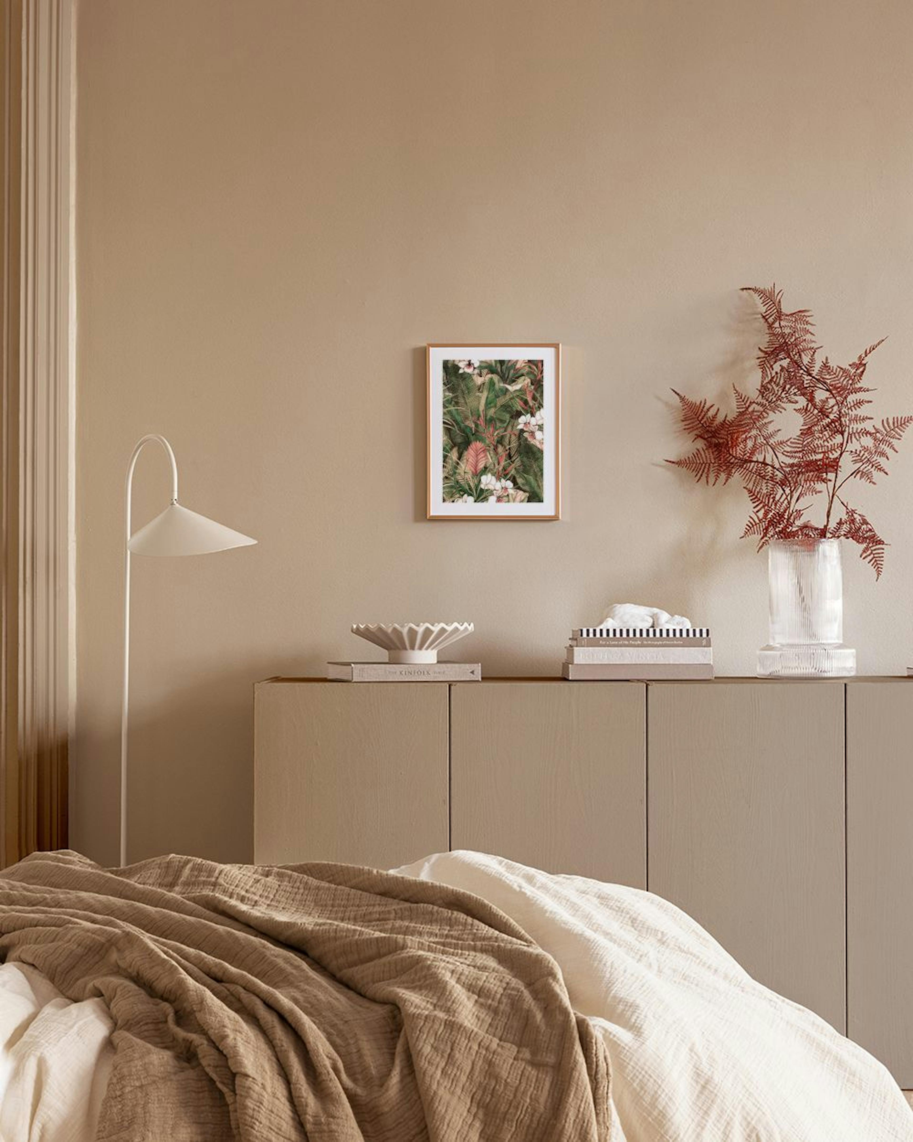 A tropical botanical print with green leaves, red and white flowers, hanging above a mauve cabinet with decorative vases.