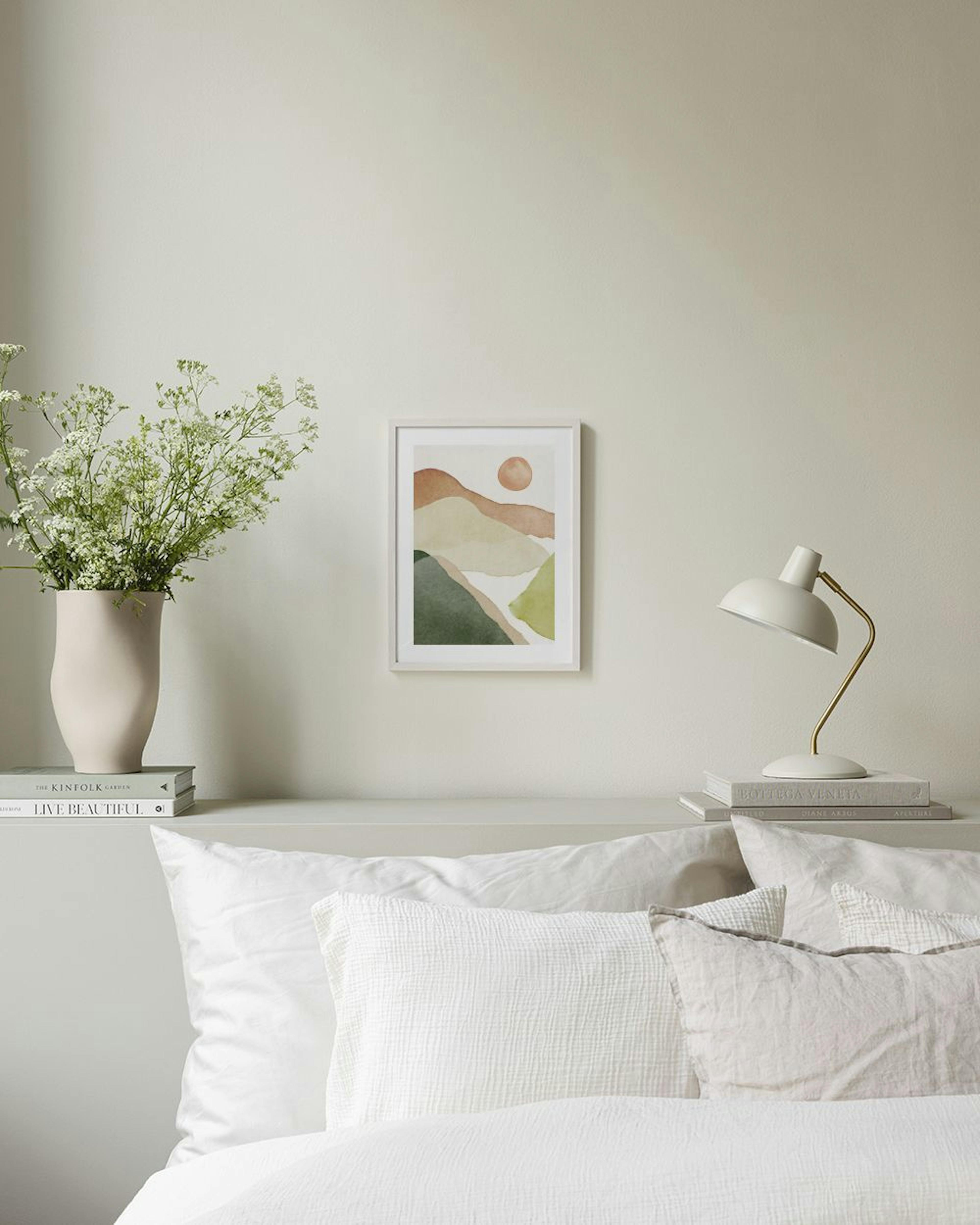 Aquarel poster met abstracte bergen in aardetinten en een oranje zon, hangend boven een wit dressoir met een vaas en boeken.