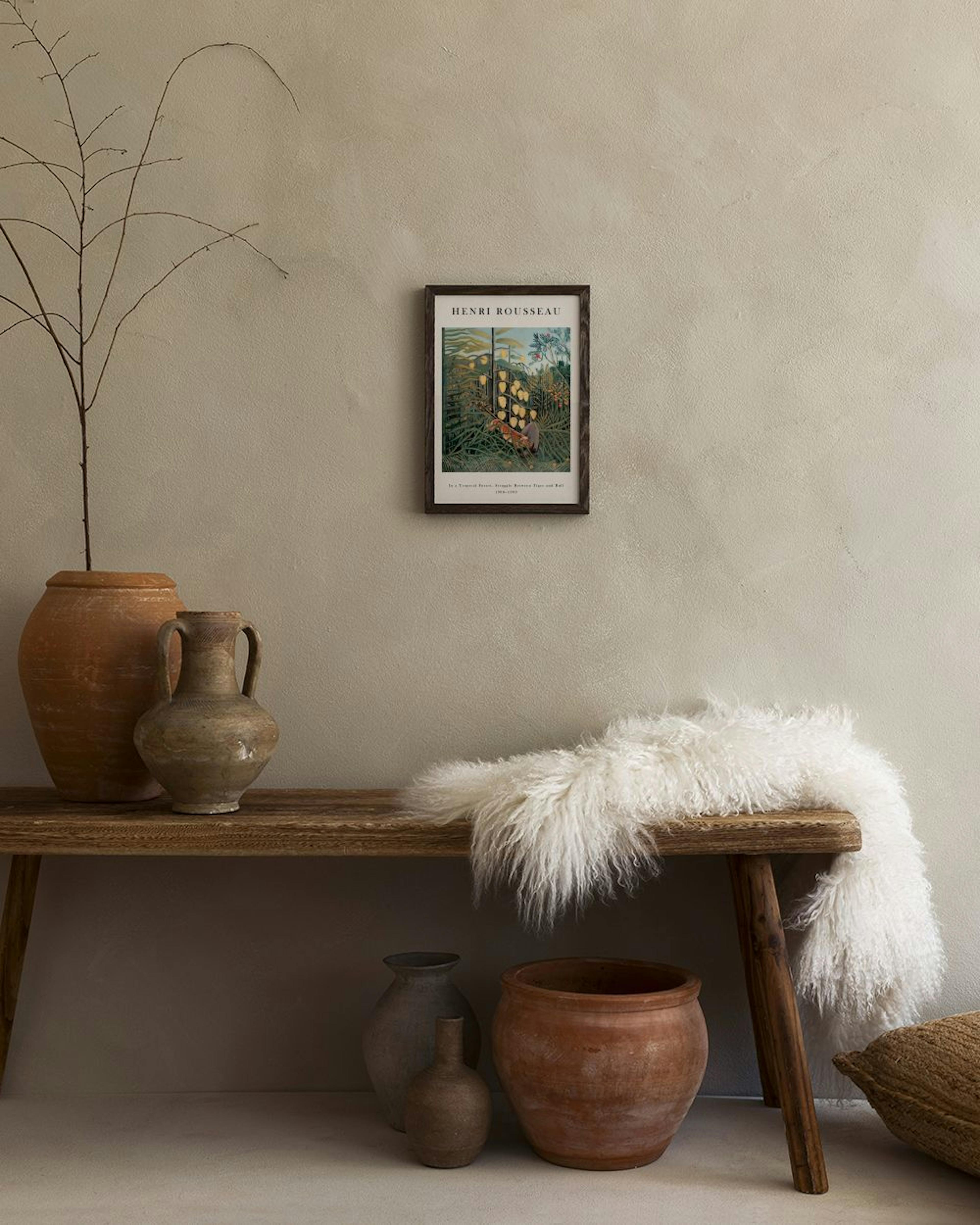 Plakat Henri Rousseau z dżunglą i tygrysem, wisi nad stolikiem z białymi wazonami i książkami.