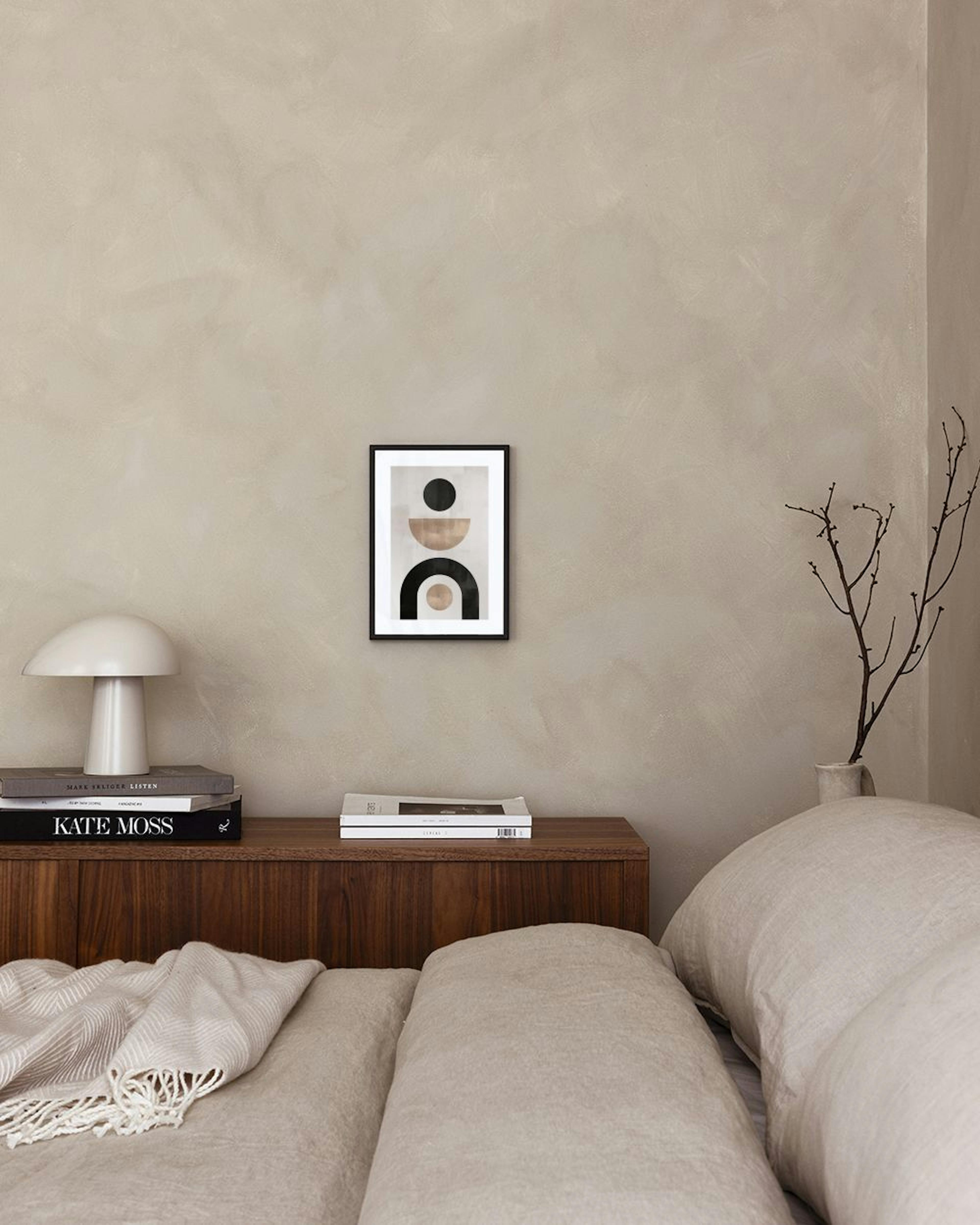 A geometric print with black, beige, and light brown shapes, including circles and arches, displayed above a white storage cabin