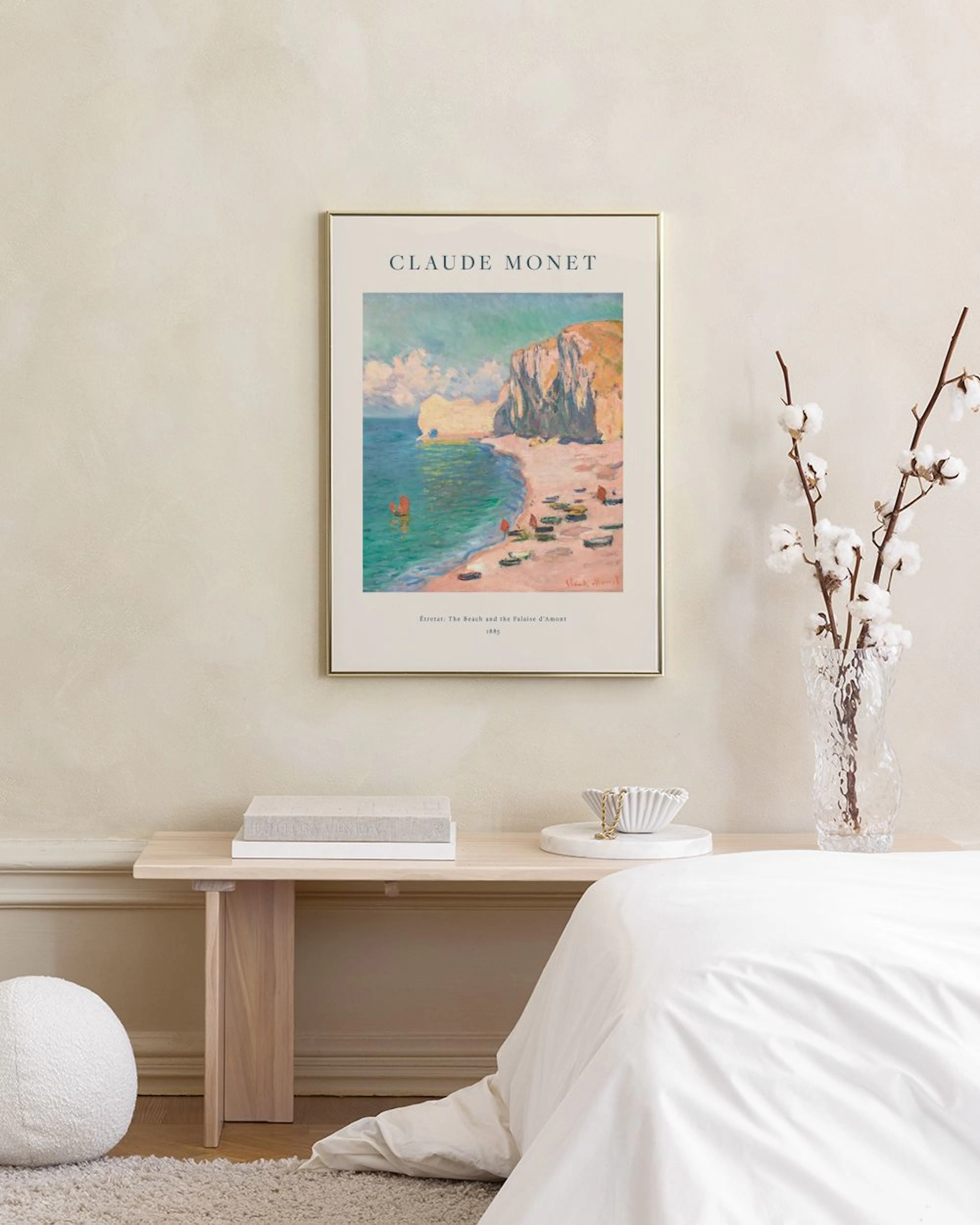 Monet-juliste rannasta, veneistä ja kallioista roikkuu makuuhuoneen seinällä sängyn ja yöpöydän yläpuolella.