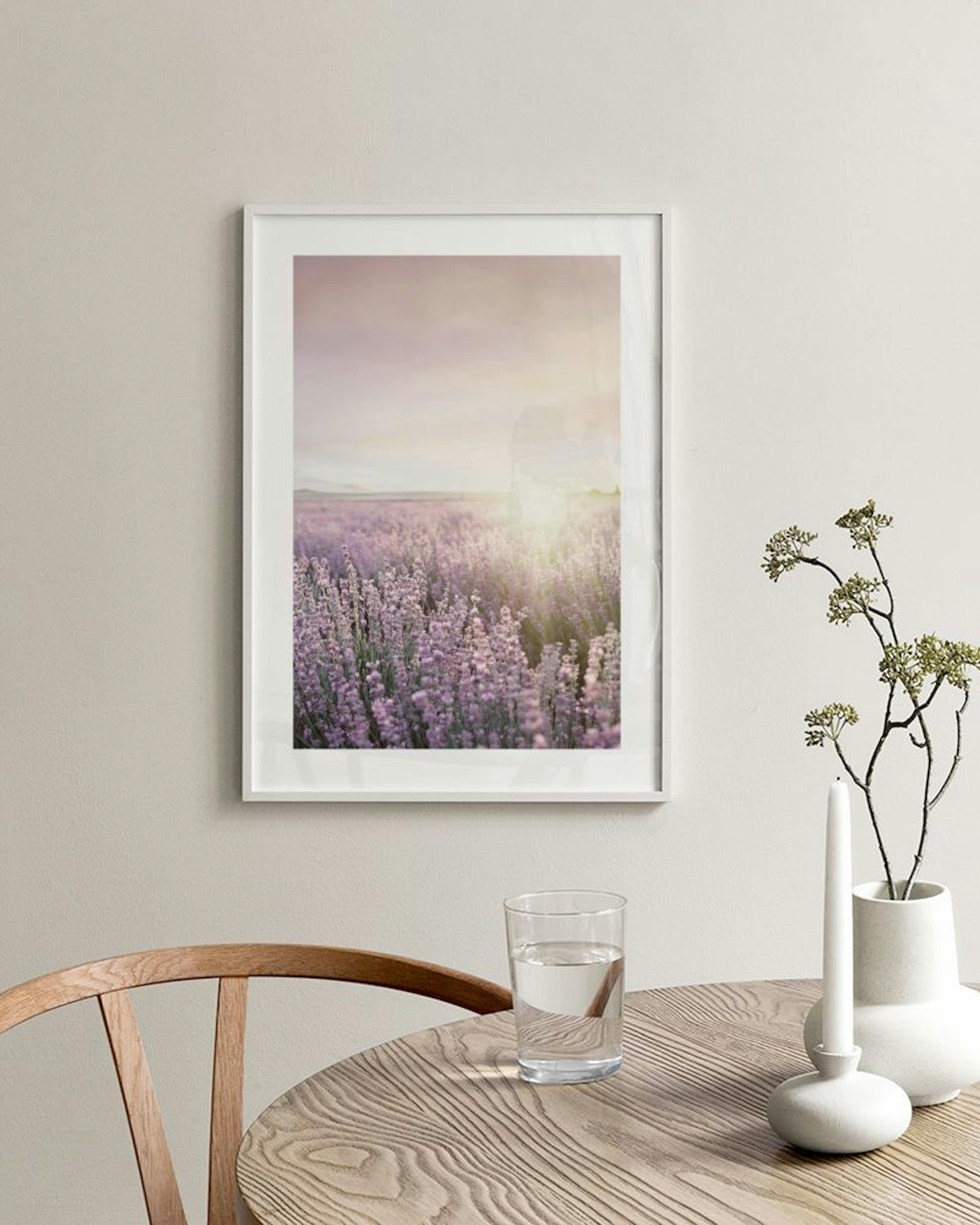 Póster de un campo de lavanda morada al atardecer sobre una mesita de noche de hormigón junto a una cama.