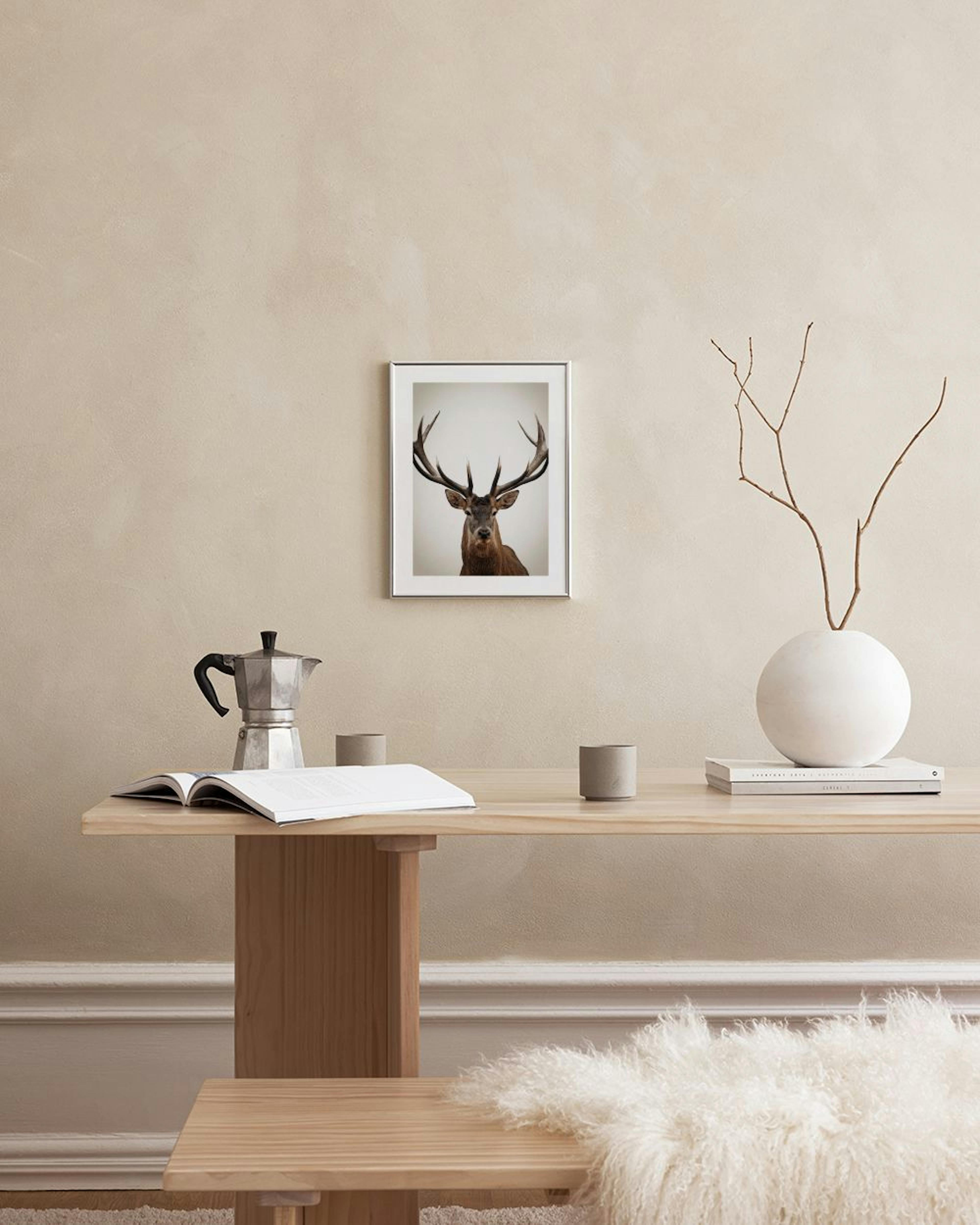 A print of a majestic deer with large antlers, hanging on a light gray wall above a modern lamp and a brown ottoman.