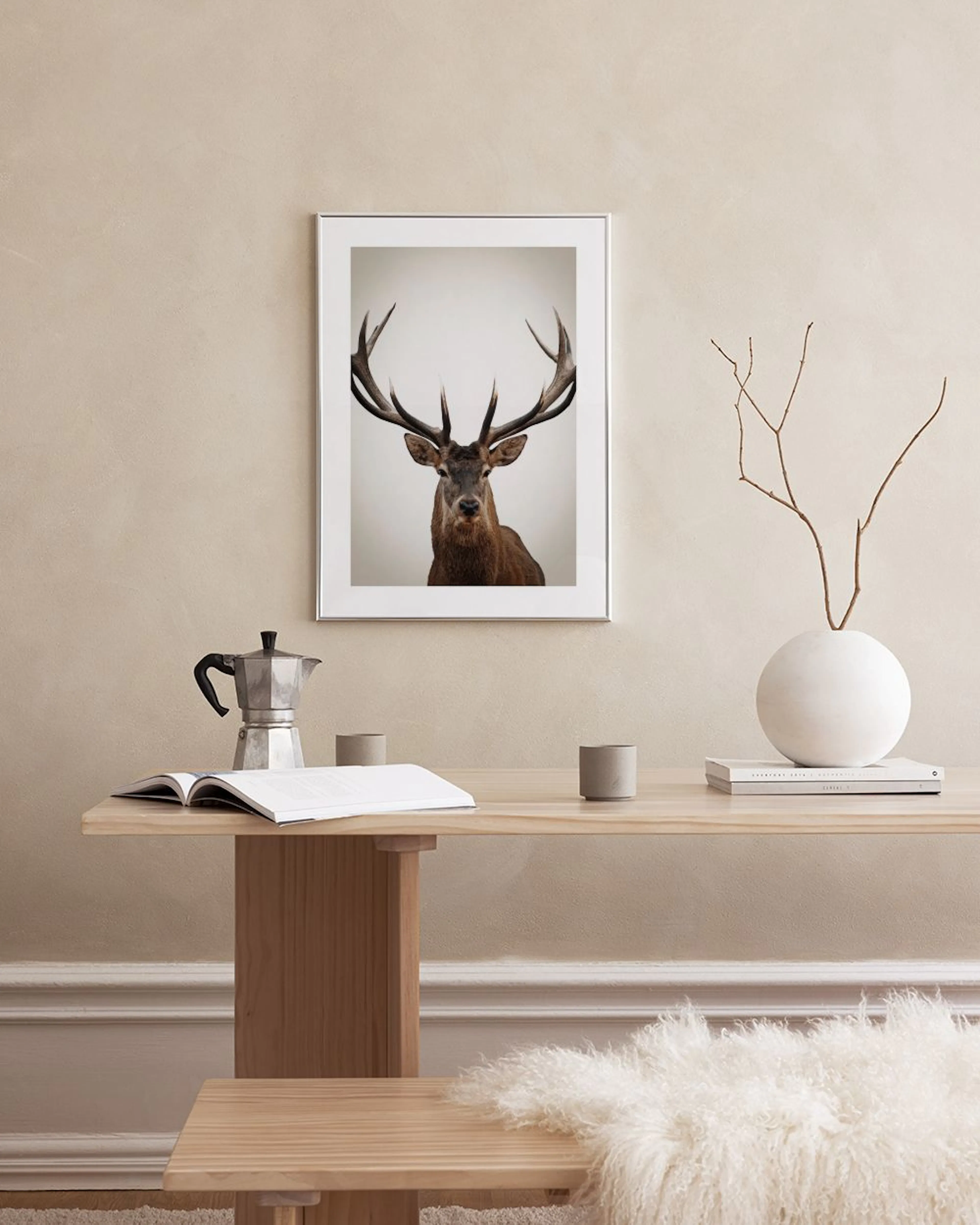 Poster med detaljerat porträtt av en ståtlig kronhjort med stora horn, hängande i ett modernt rum.