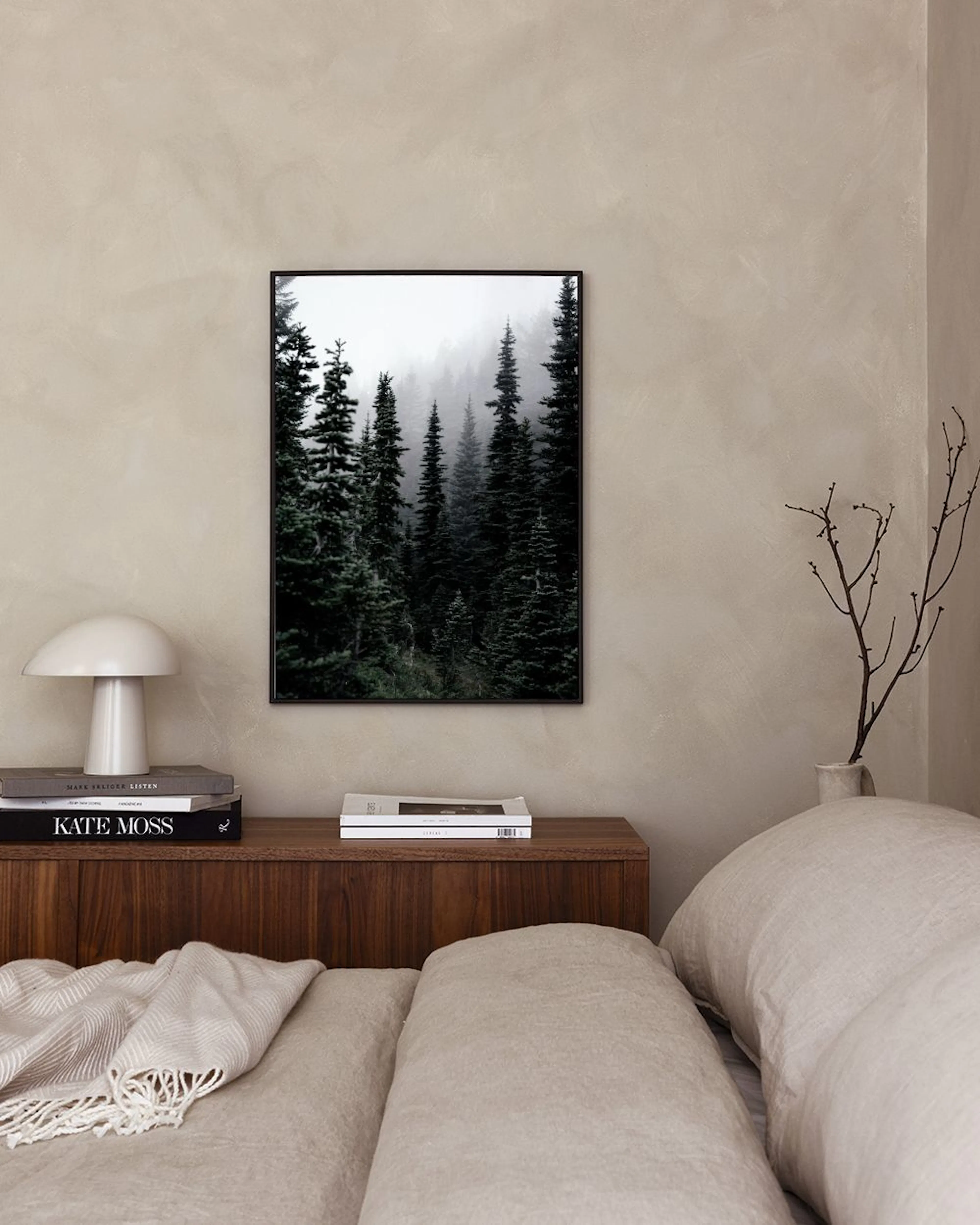 Affiche forêt brumeuse avec des sapins sombres, affichée dans un intérieur minimaliste avec une chaise verte et un vase gris.