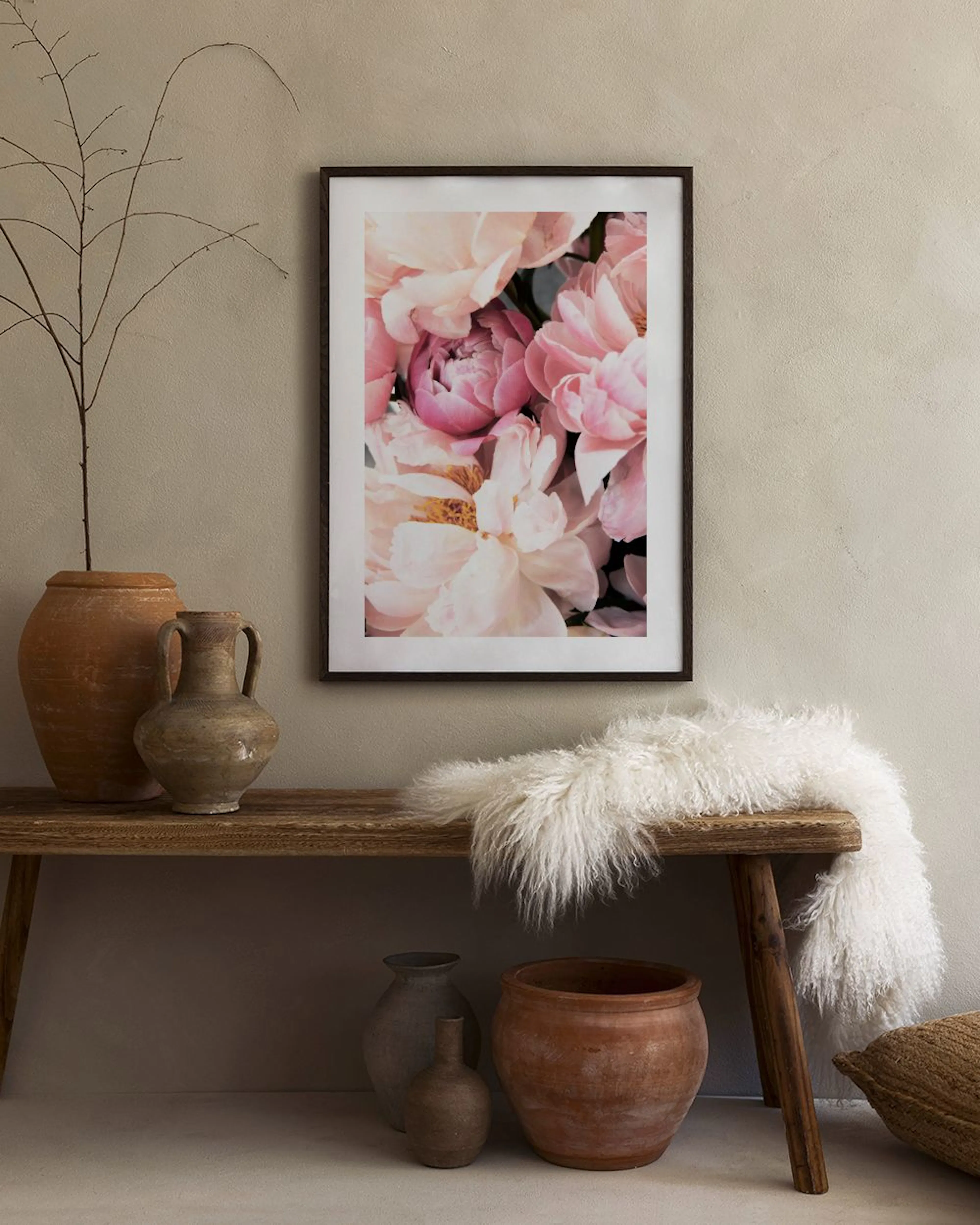 Poster med rosa och vita pioner, hängandes i ett rum med en mörkrosa sammetsfåtölj.