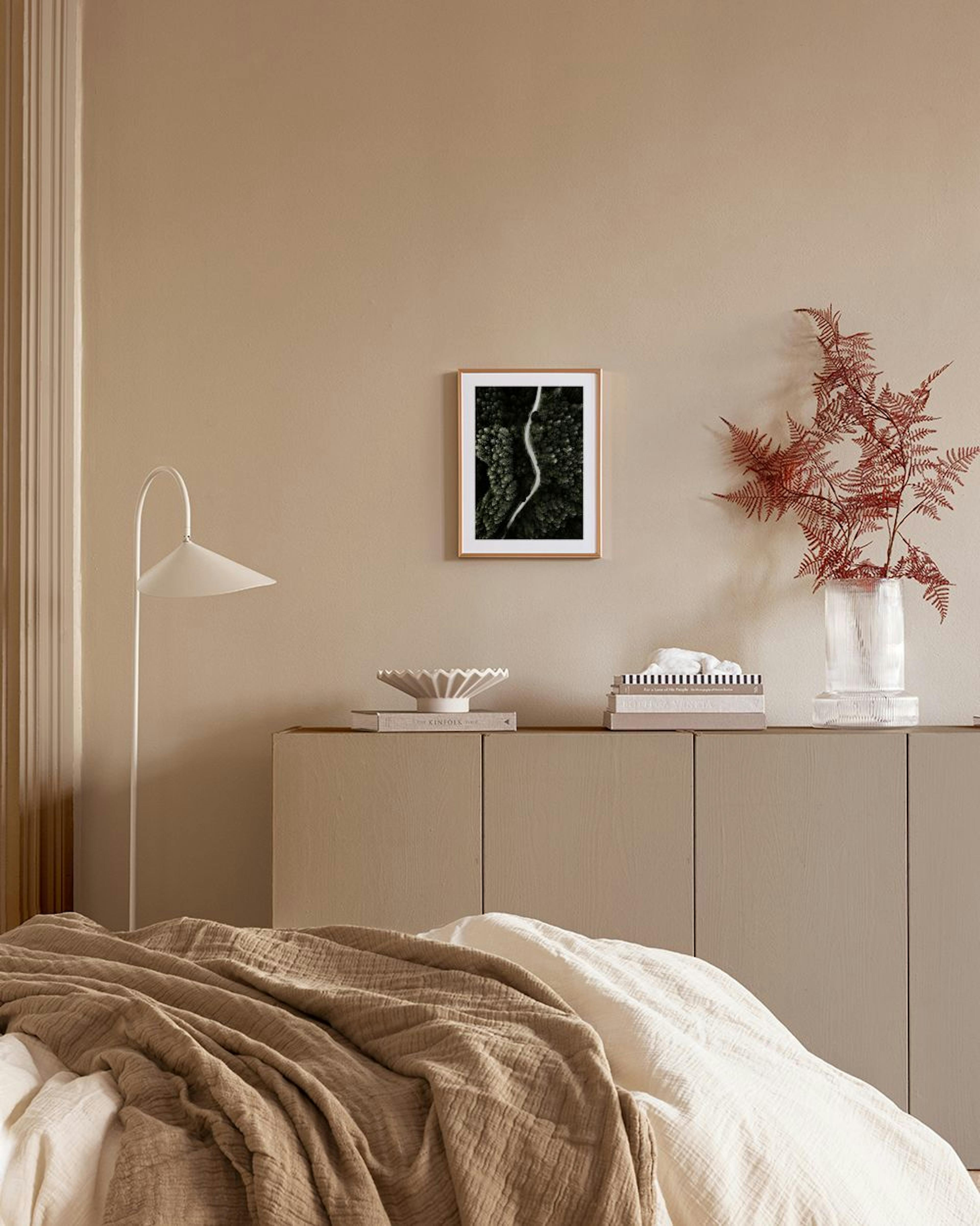 Poster van een kronkelende weg door een dicht bos, hangend boven een witte kast in een moderne woonkamer.