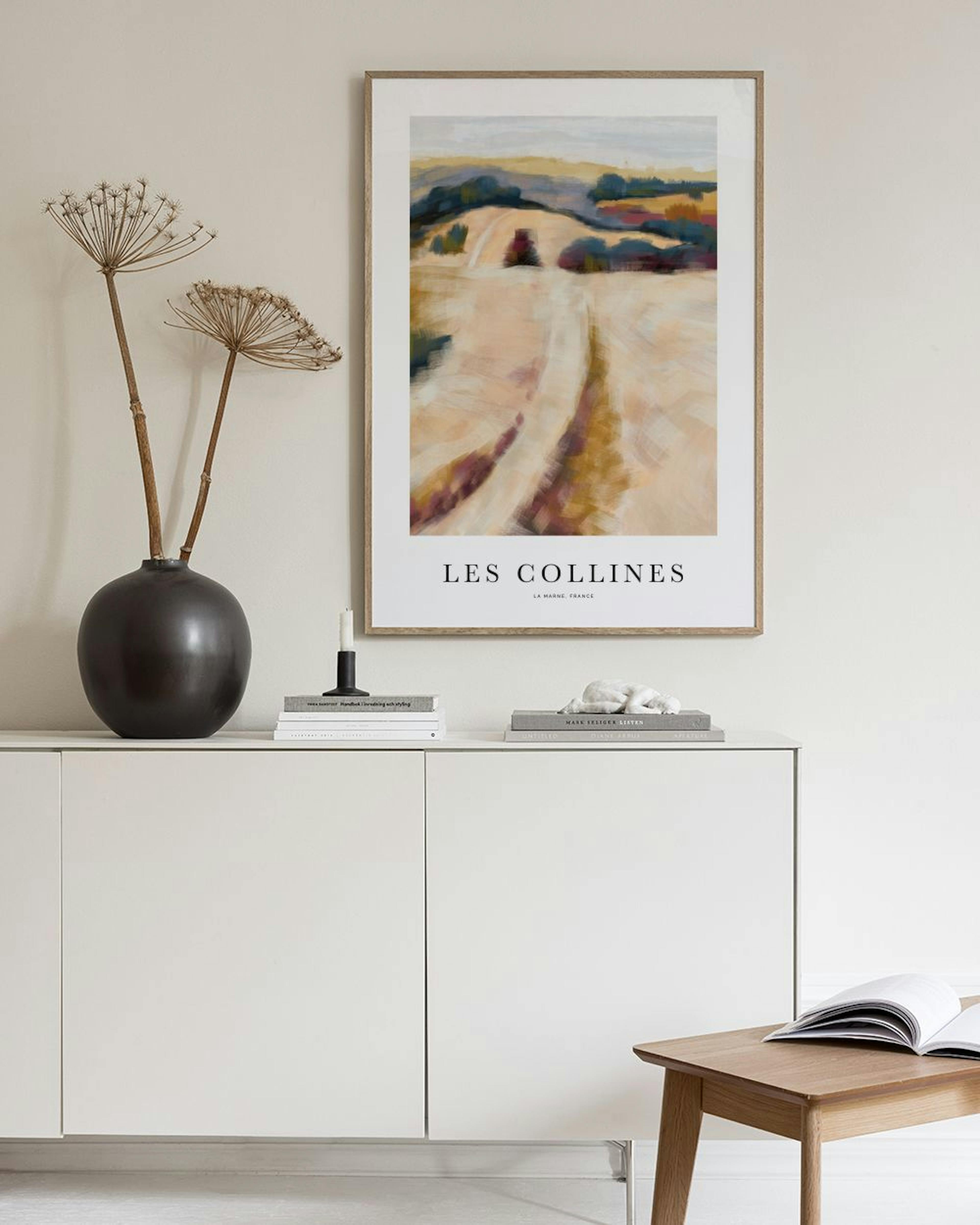 A print of an abstract landscape with rolling hills in warm tones, hanging above a beige armchair in a modern living room.