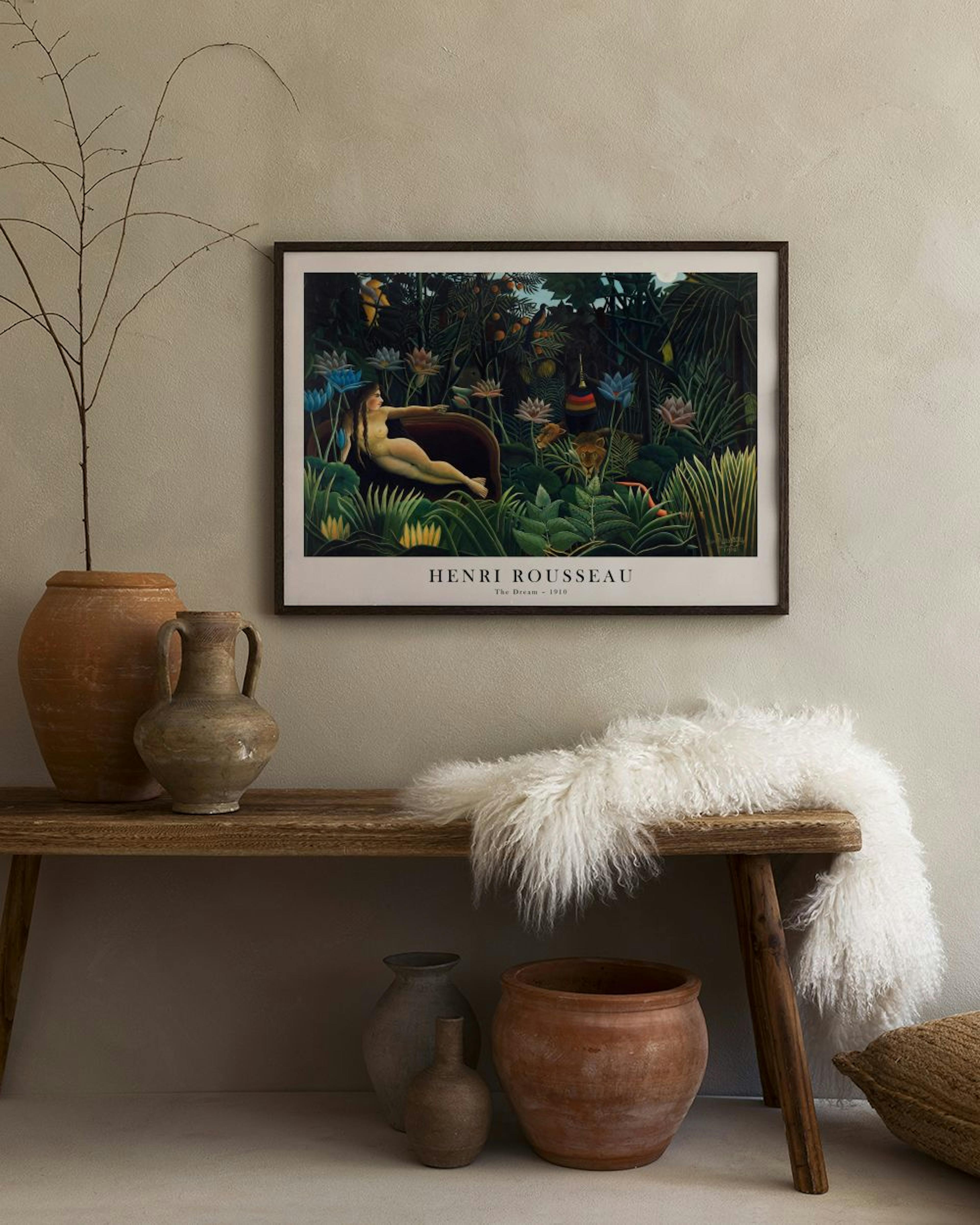 A print of Henri Rousseaus The Dream, featuring a reclining nude woman in a lush jungle, displayed on a sage green wall above a 