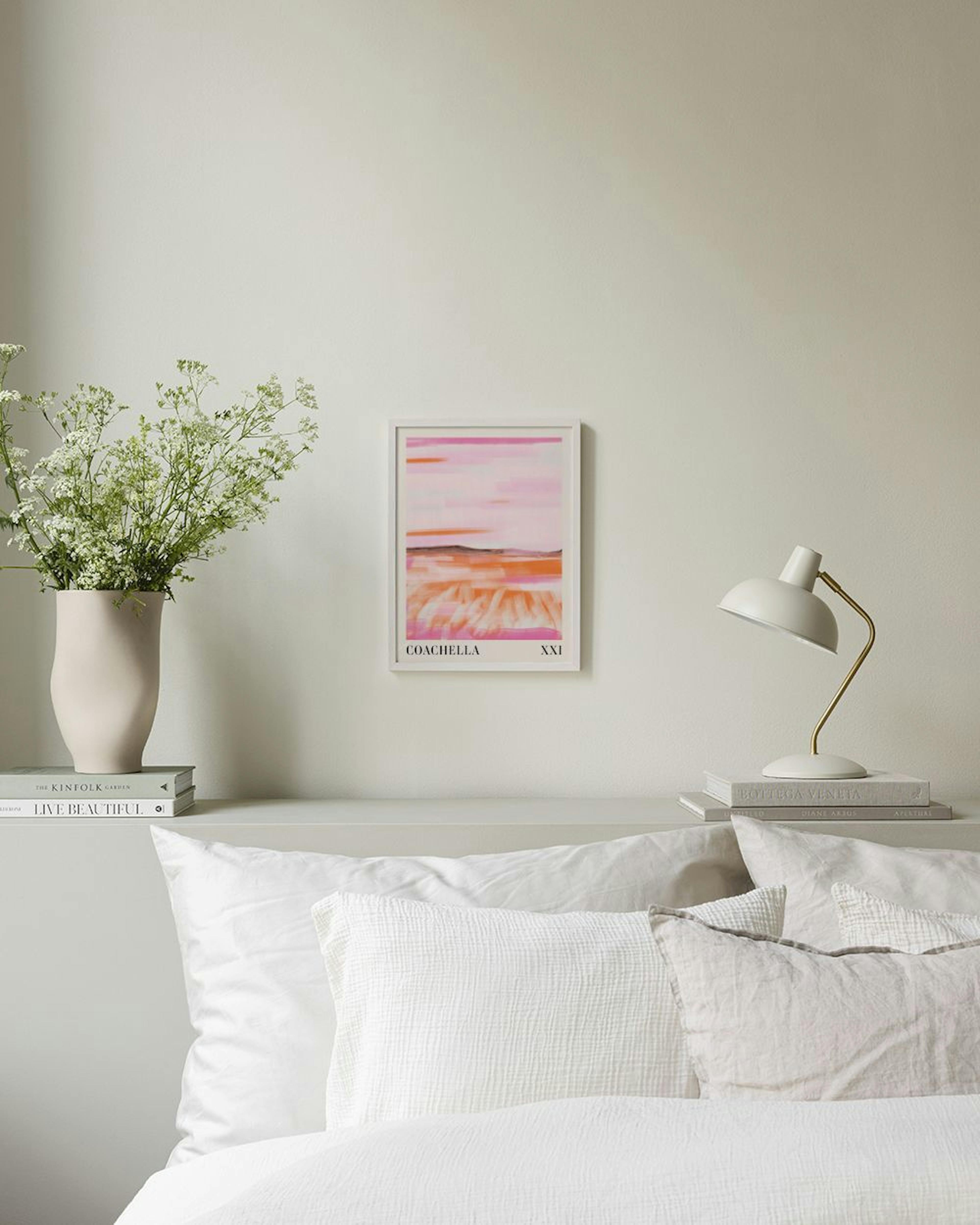 Abstract print in bright pink and orange brushstrokes, with Coachella text, hanging above a white storage cabinet with decorativ