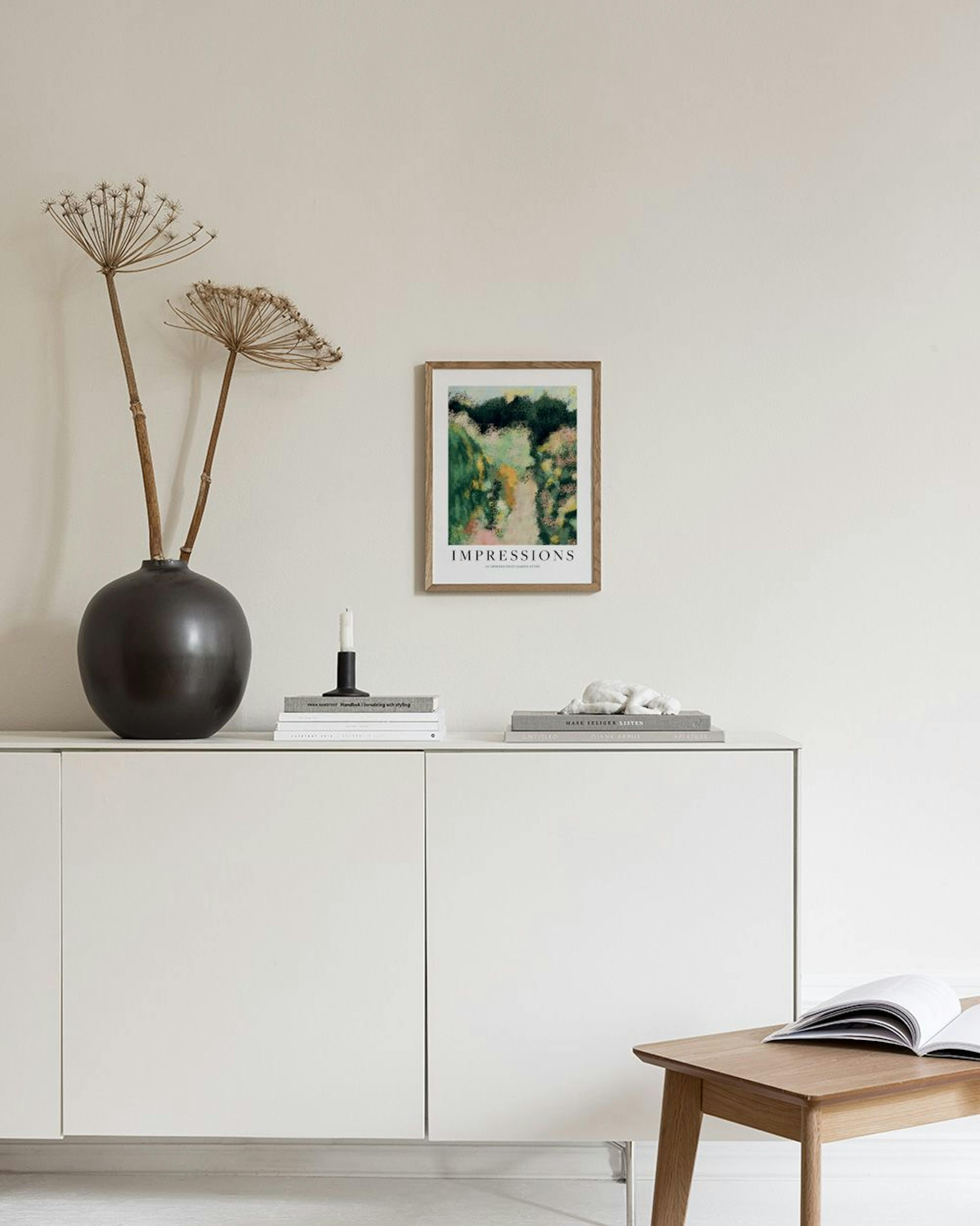 Poster de jardim impressionista com pinceladas de verde, amarelo e rosa, pendurado numa parede clara acima de um banco com um li