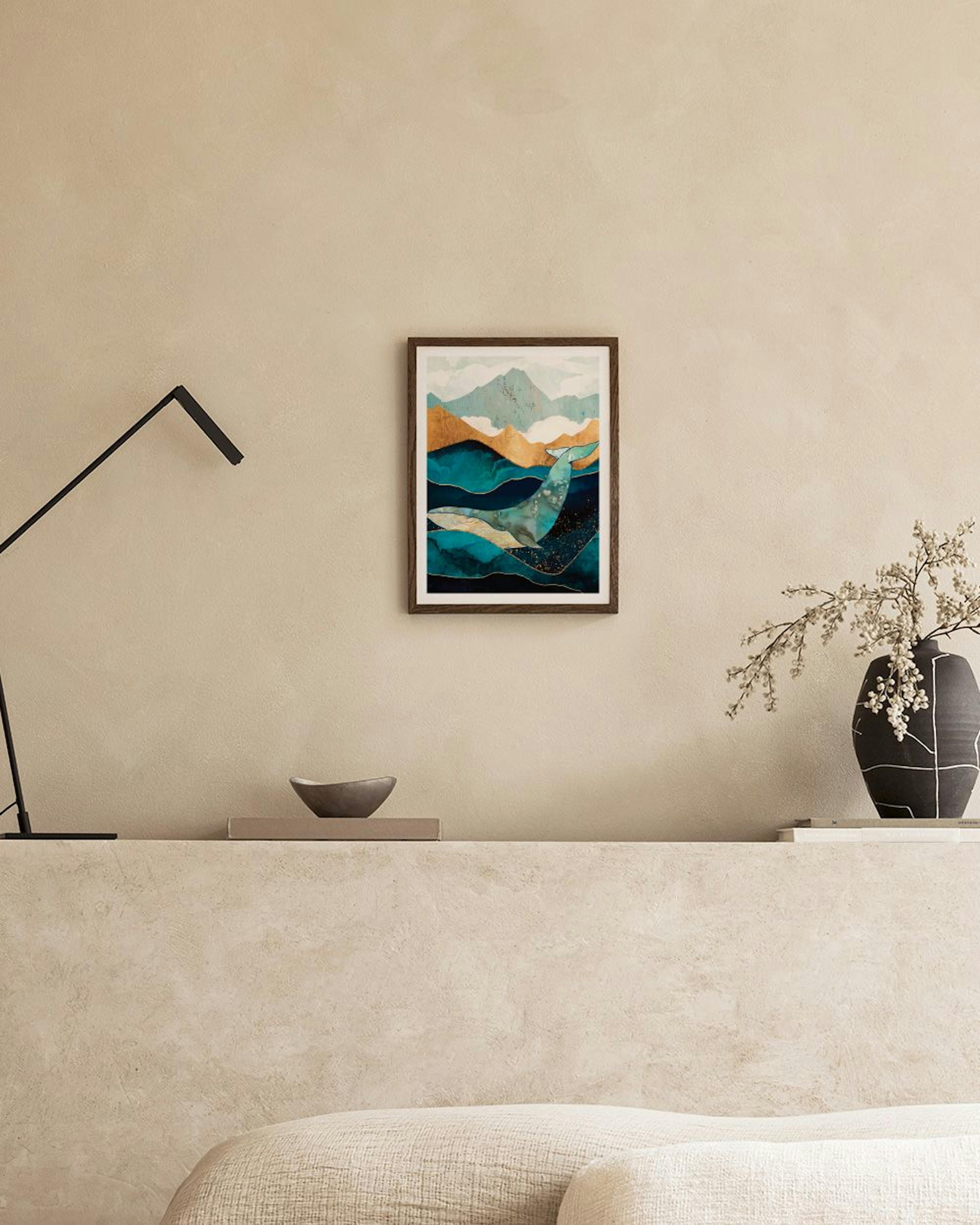 Póster de ballena abstracta en tonos turquesa, azul y dorado sobre un mueble negro con libros y adornos.