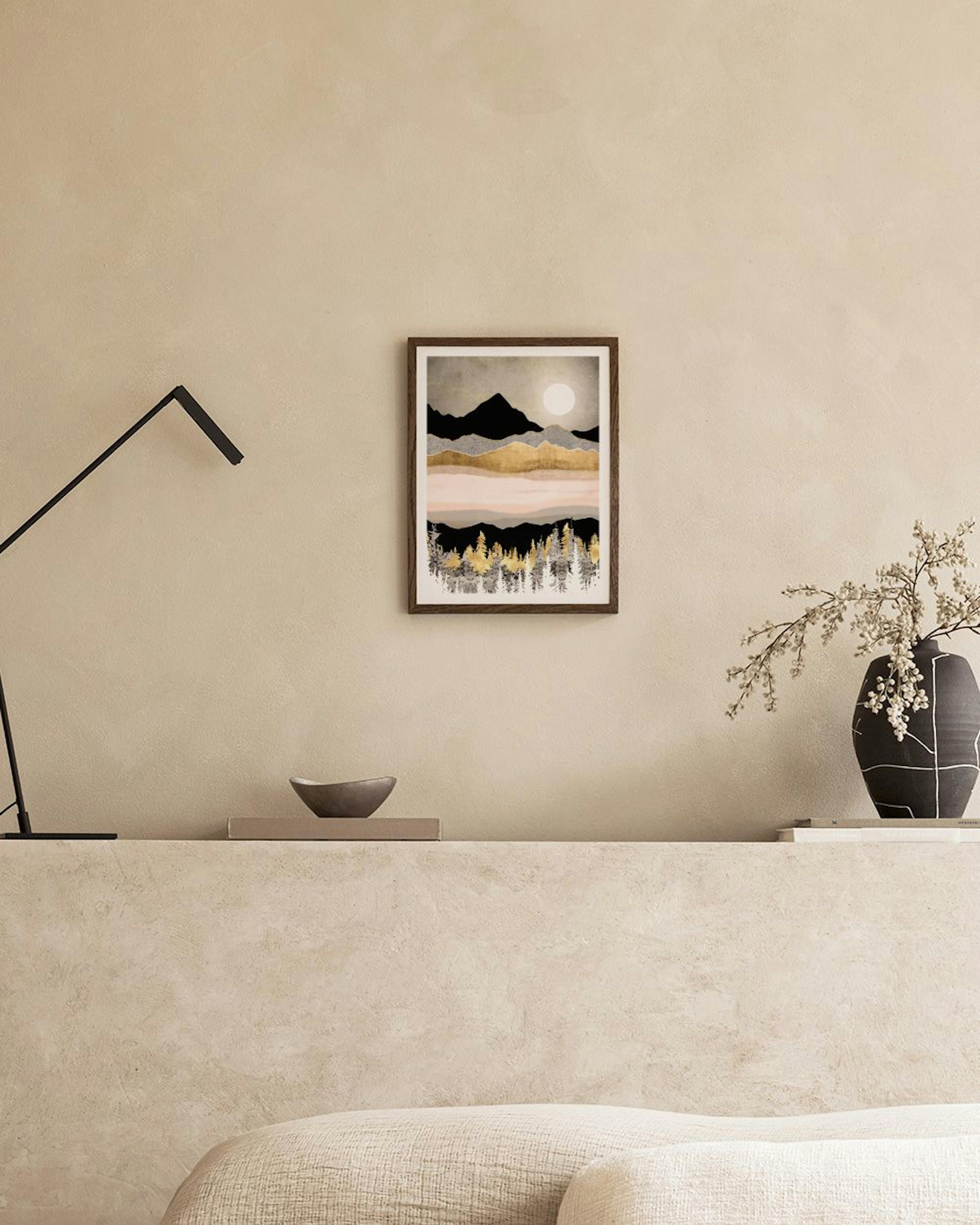 Póster de paisaje montañoso con luna blanca, montañas negras y doradas, y árboles dorados y plateados, exhibido sobre una repisa