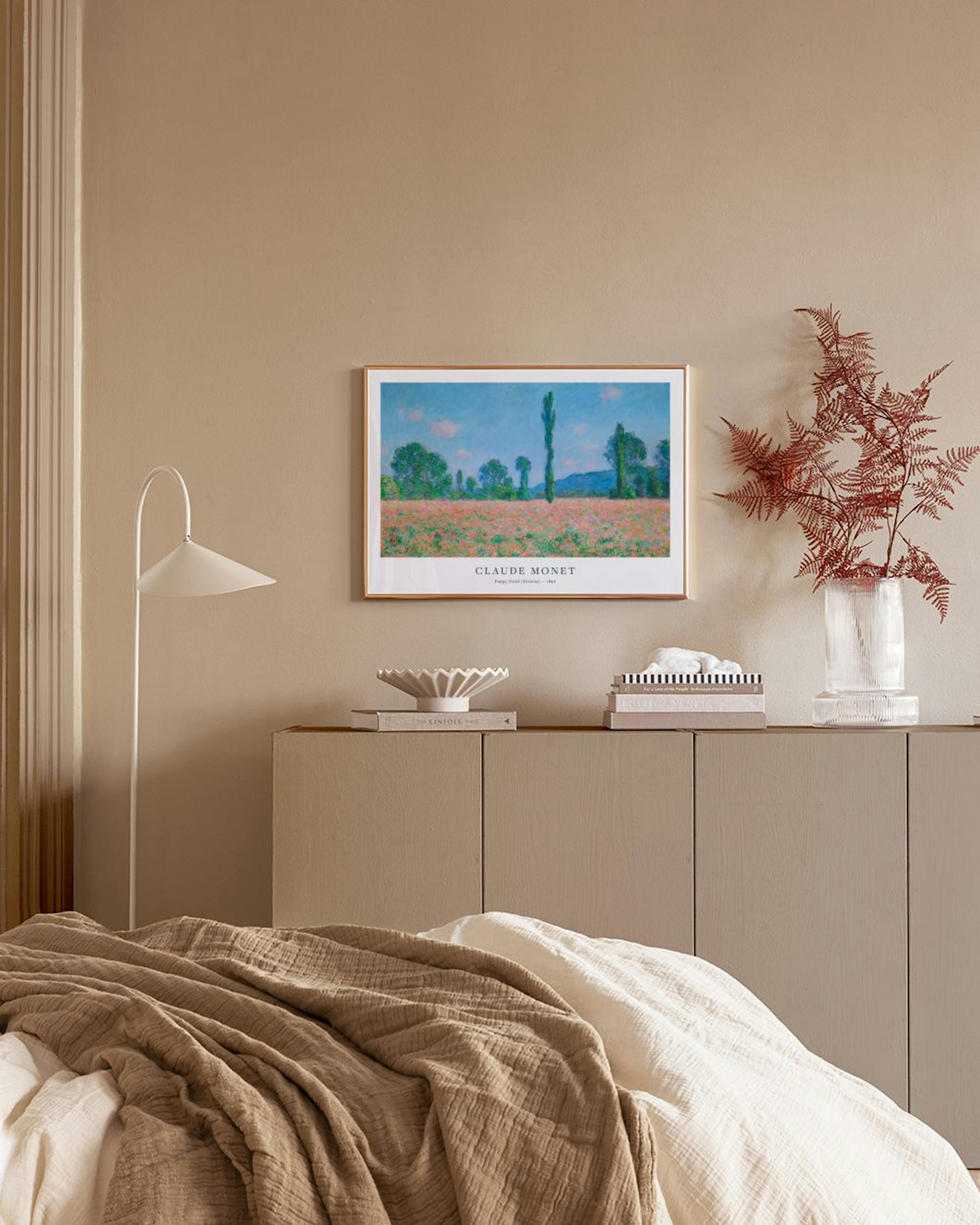 Claude Monets konstposter med ett fält med gröna och orange toner under en blå himmel, hängande ovanför en vit byrå med en vas o