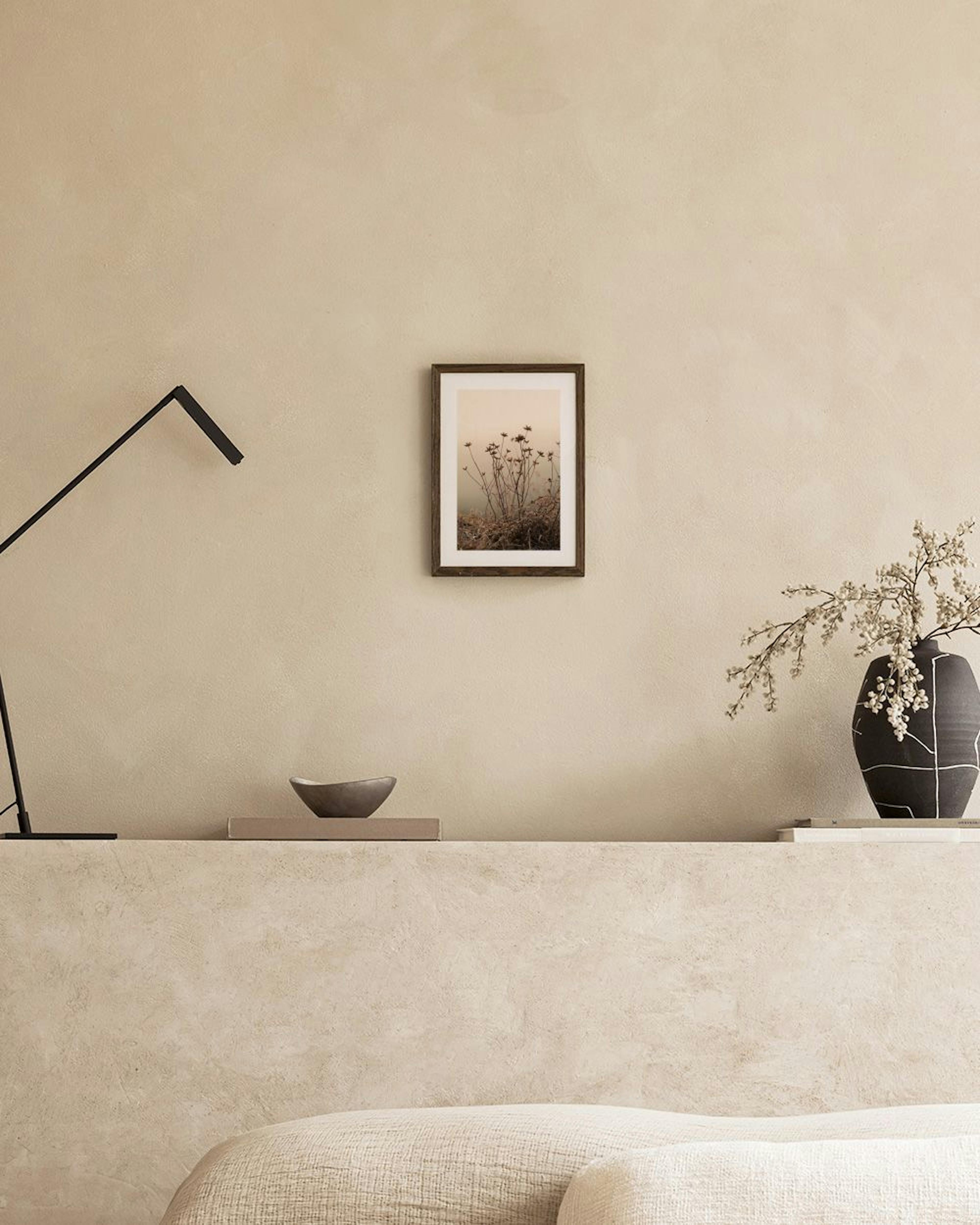 Póster de plantas secas y finas sobre un fondo brumoso, exhibido en una sala de estar minimalista.