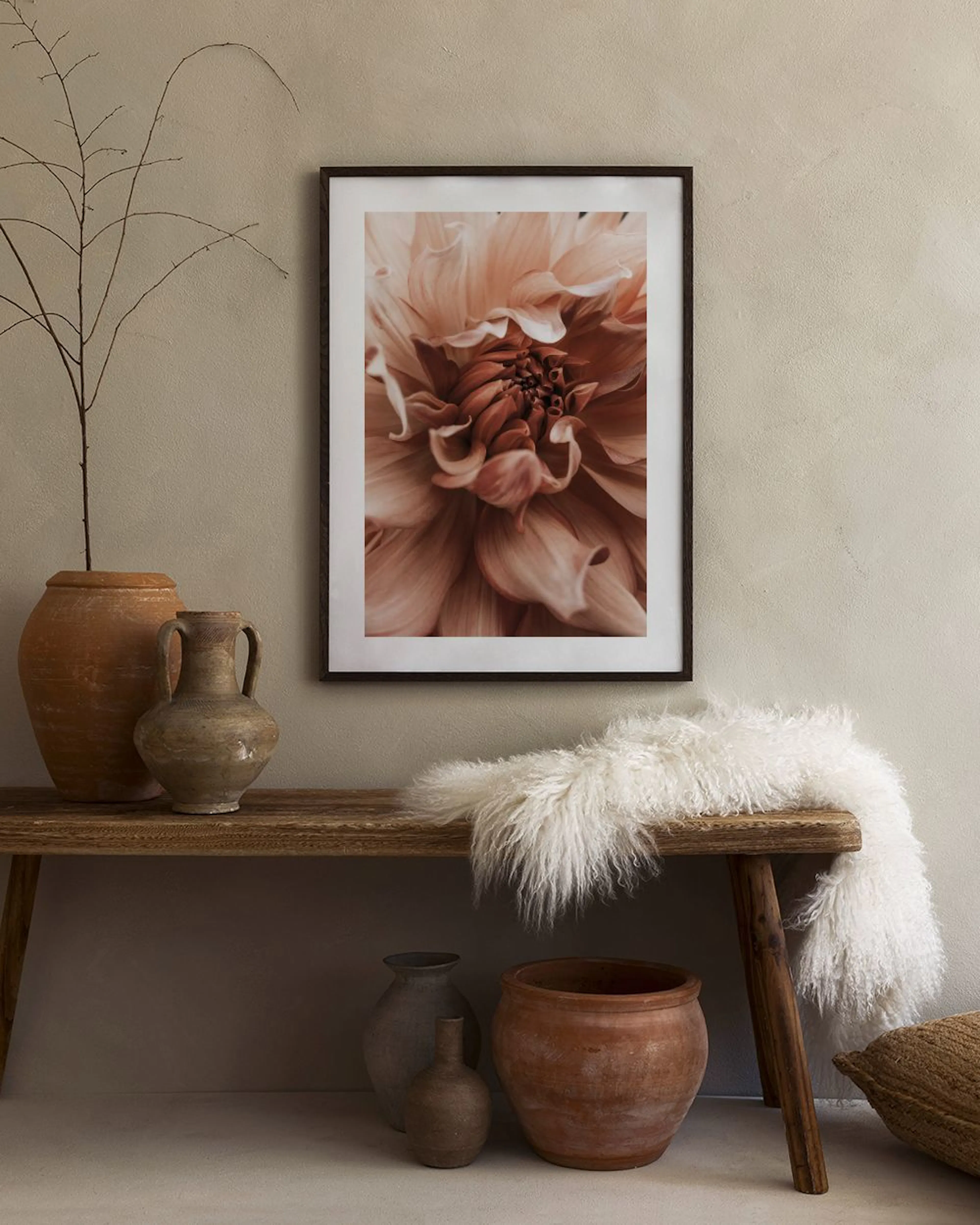Plakat med en stor, detaljert dahlia i ferskenrosa og bruntoner, henger i et moderne rom over et sidebord.