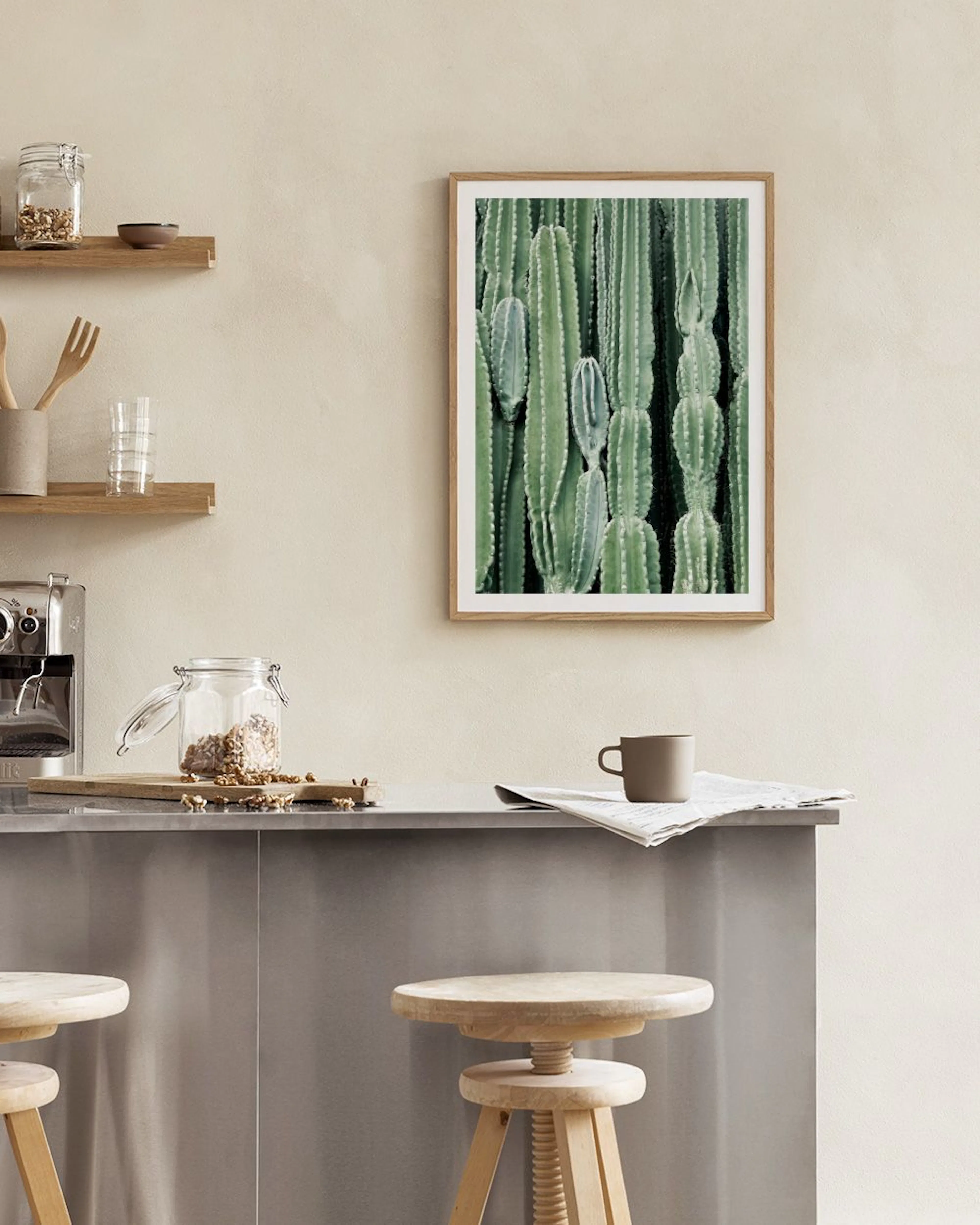 Affiche murale de cactus verts avec des détails, affichée au-dessus dune table avec des citrons et un livre.