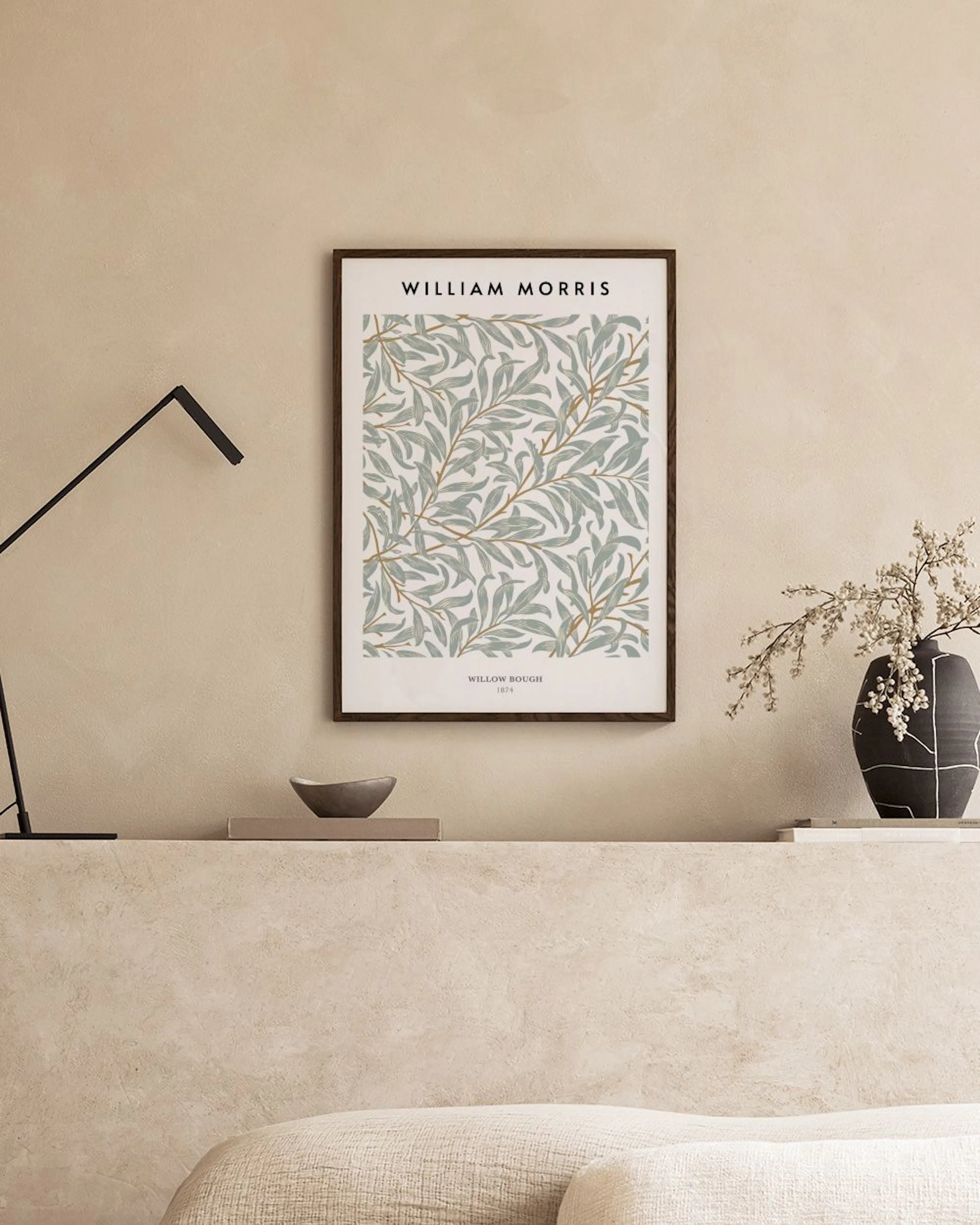 William Morris Poster Willow Bough mit grün-beigen Blättern an Zweigen, über einem Beistelltisch und Hocker.