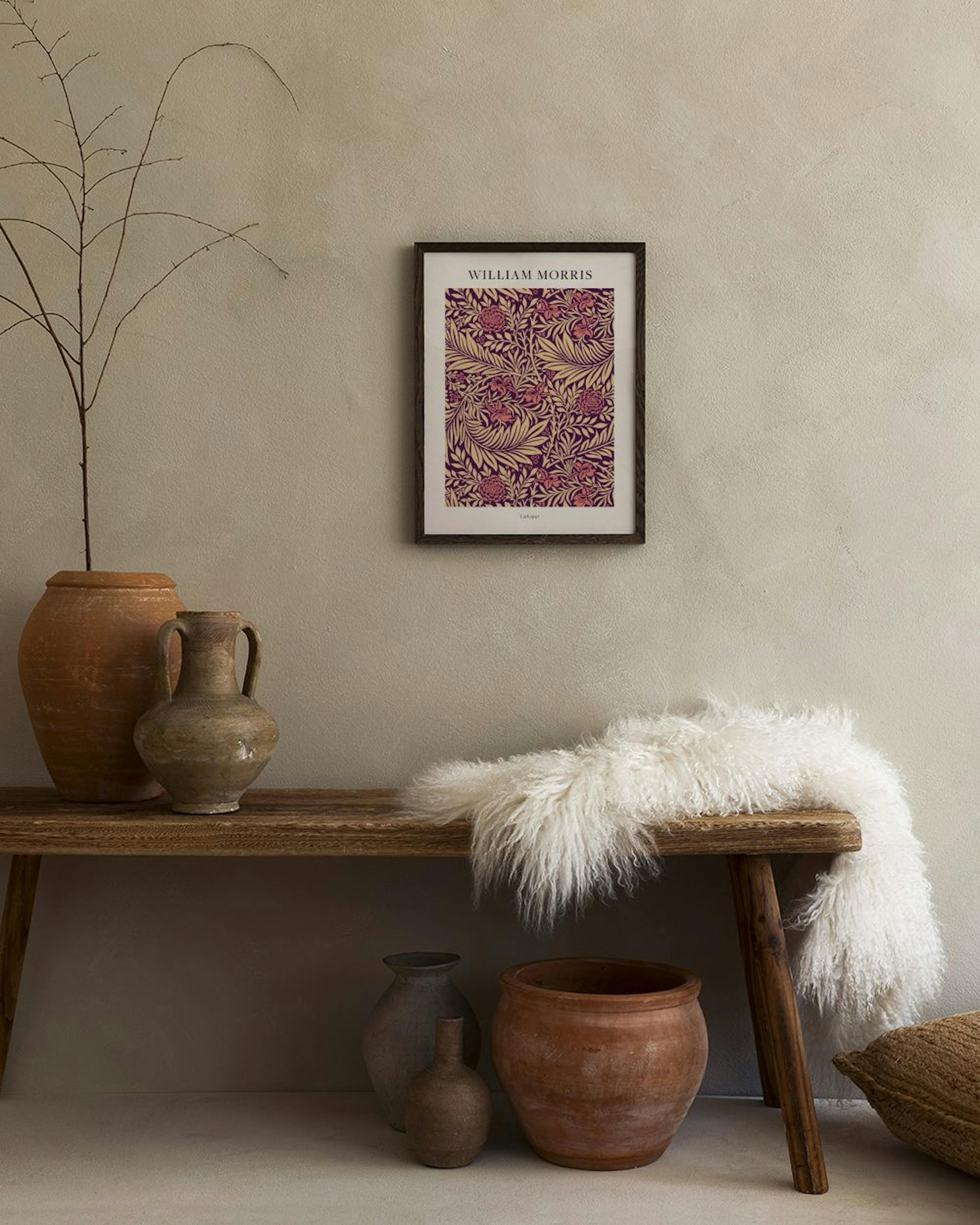 A William Morris print featuring a floral pattern with red flowers and golden leaves on a deep purple background, hanging in a l