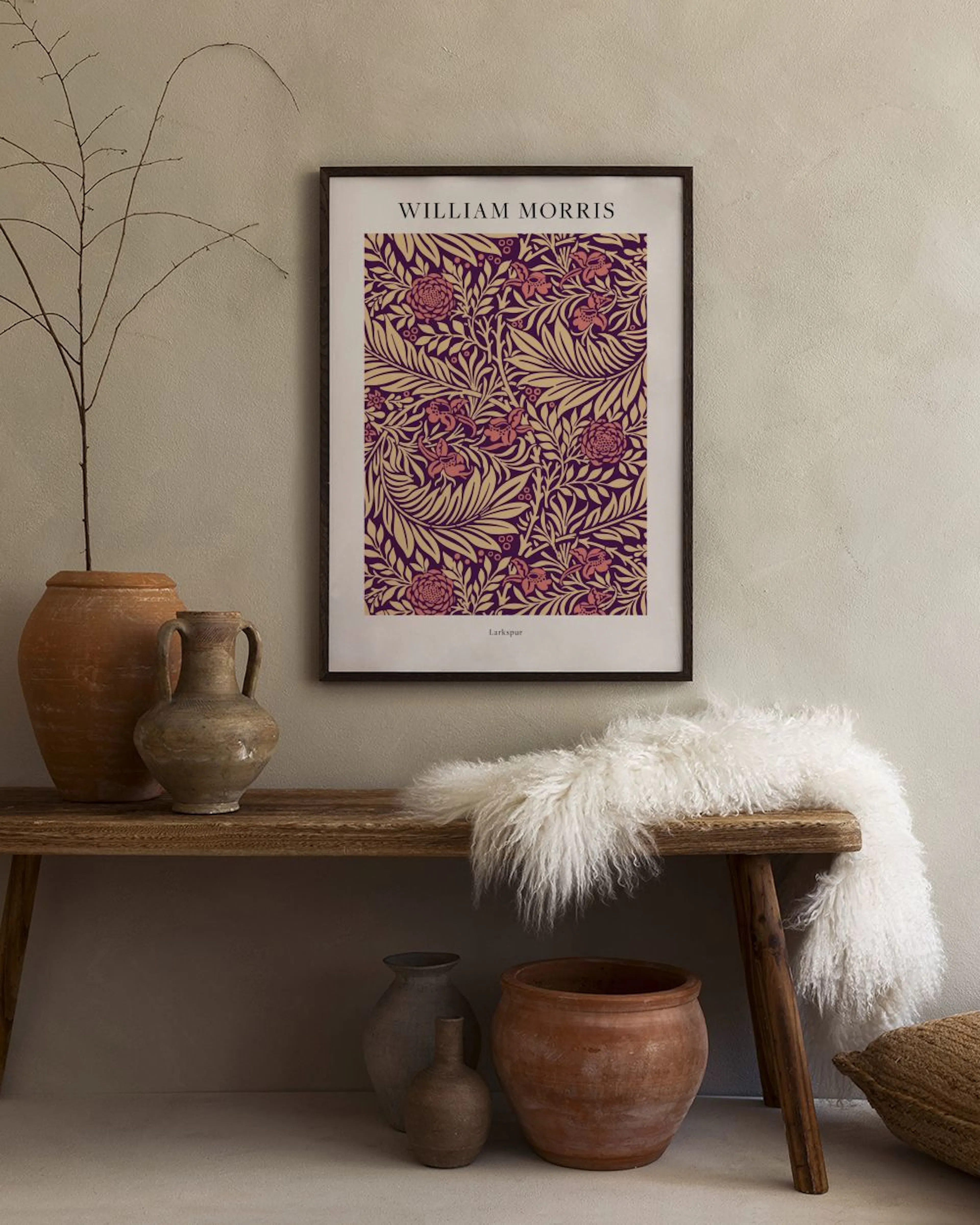 William Morris print with a floral pattern in red and yellow on a dark purple background, displayed in a room with a white lamp 